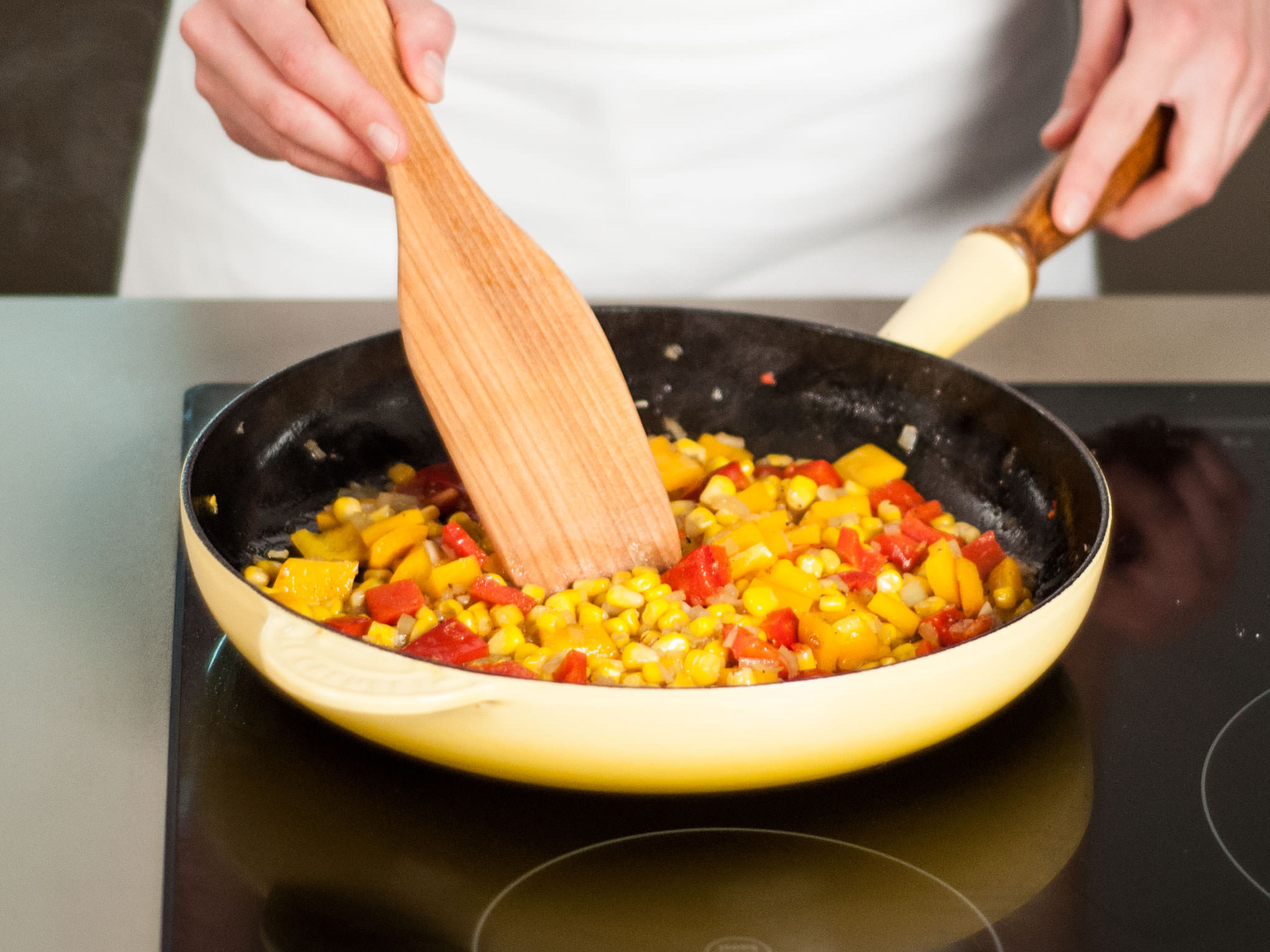 In a frying pan, sauté onion, garlic, peppers, and corn in some vegetable oil over medium heat for approx. 5 - 7 min. until onions are translucent and garlic is lightly browned. Season with salt and pepper.