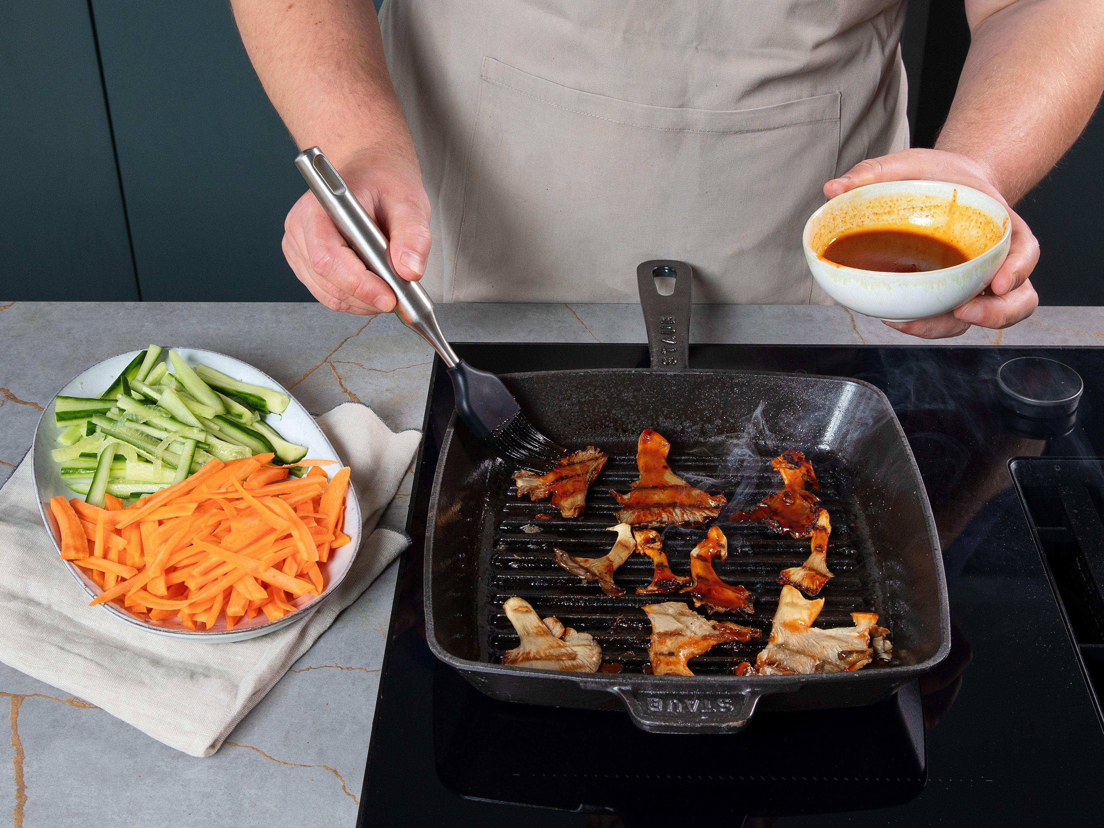 Knoblauch und Ingwer fein in eine kleine Schüssel reiben. Anschließend Sojasauce, Apfelsaft, Honig, Sesamöl und Gochujang hinzufügen und gut verrühren. Austernpilze entweder auf dem heißen Grill oder in einer Grillpfanne (am besten mit einer Grillpresse) scharf anbraten. Nach ca. 2 Min. mit der Bulgogi-Soße bestreichen, wenden und weitere ca. 1 Min. grillen. Die andere Seite ebenfalls mit Soße bestreichen, erneut wenden und nochmals ca. 1 Min. grillen.