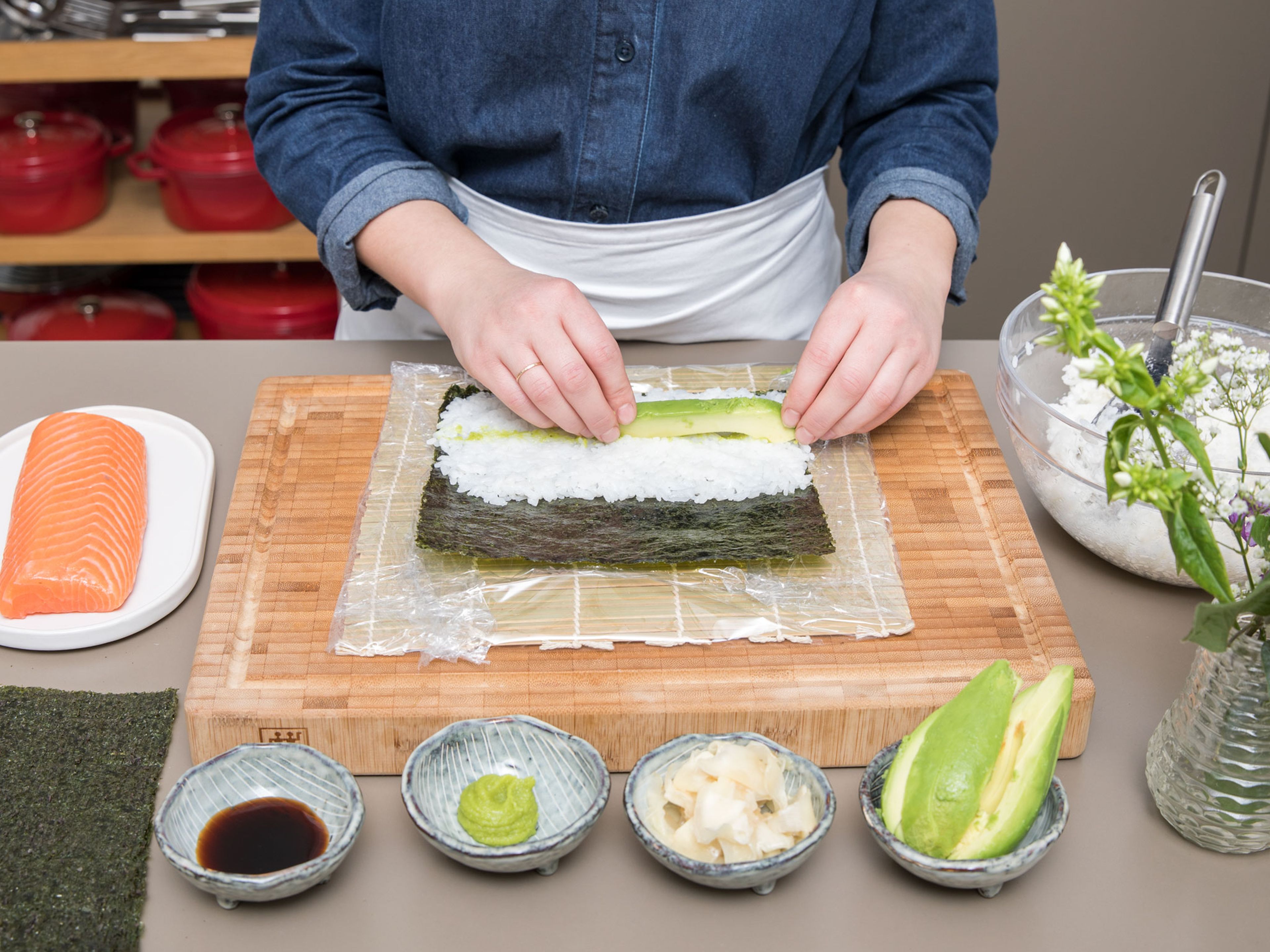 For avocado maki, slice avocado. Wrap sushi mat in plastic wrap and place a nori sheet on top. With damp hands, spread sushi rice onto the lower half of nori sheet and spread some wasabi and place sliced avocado in the center of the rice. Roll together tightly using the sushi mat and cut off overhang. Slice into equal-sized avocado maki.