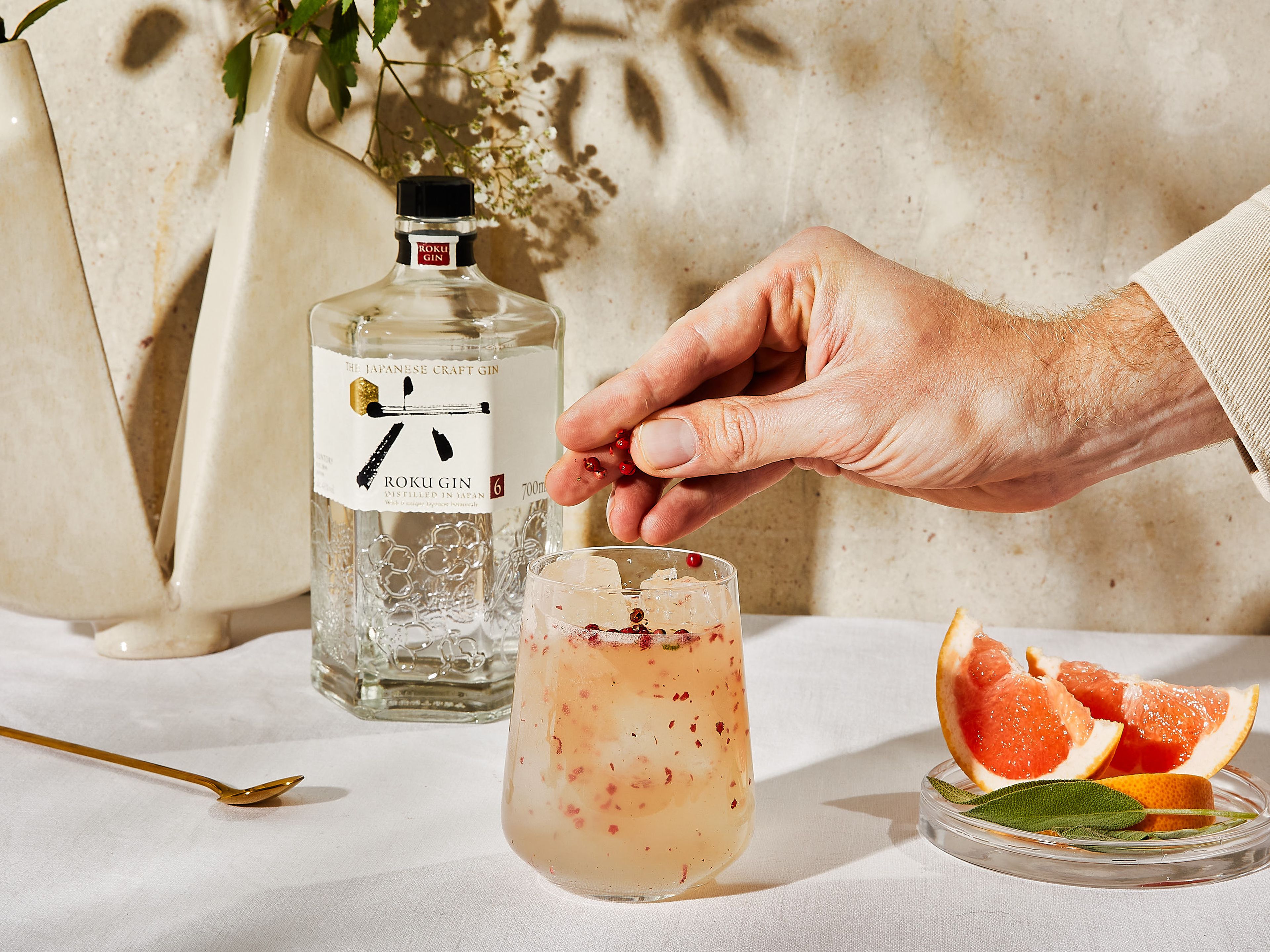 Garnish with a slice of grapefruit, pink peppercorns and sage.