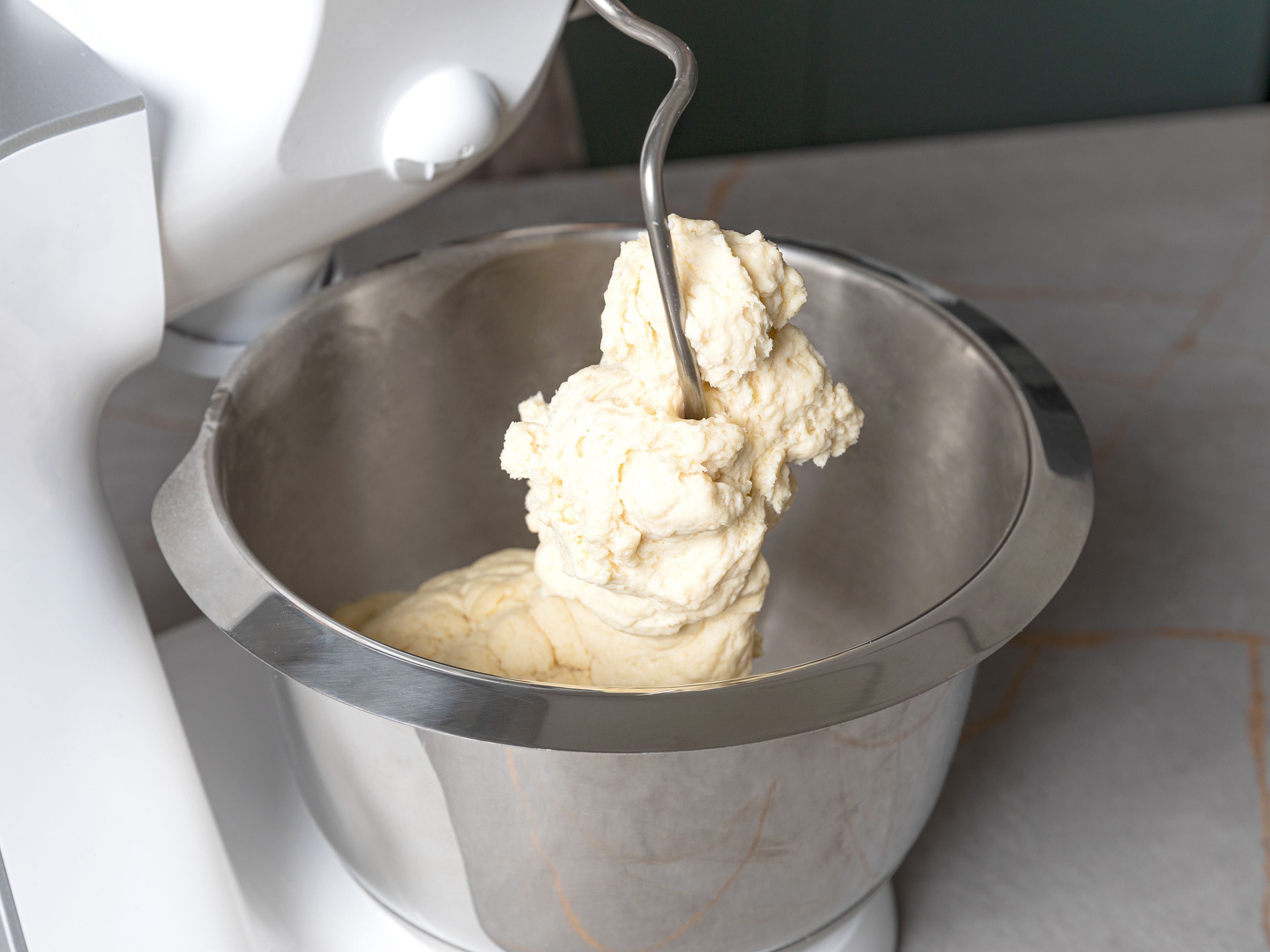 Preheat the oven to 175°C/347°F. In a bowl, mix flour, baking powder and a pinch of salt. Add quark, most of the milk, half of the powdered sugar and oil, and mix everything with a stand mixer with a dough hook until a smooth dough forms. If the dough is too sticky, add some more flour and mix. Cover the dough and set aside.