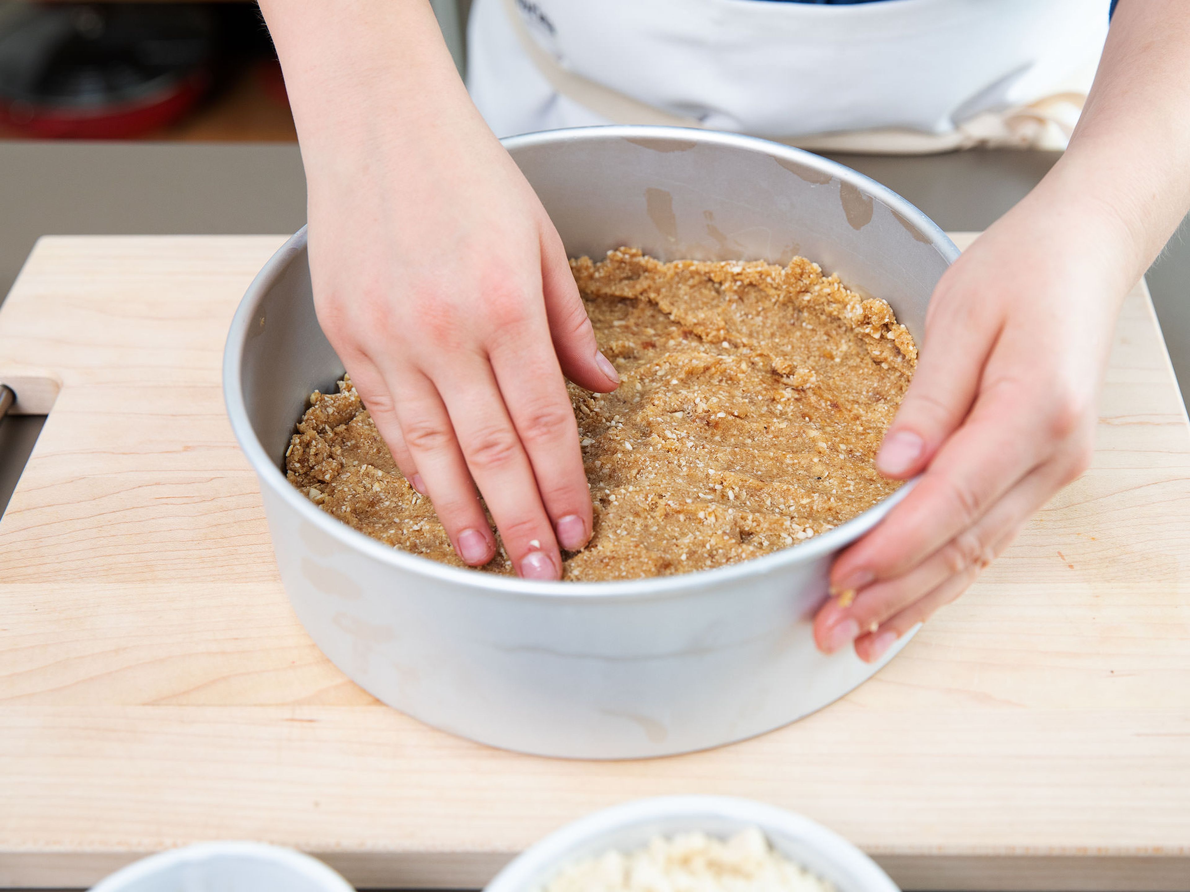Transfer the date-cashew mixture into a baking pan or springform pan. Spread and press down firmly. Add ground almonds, maple syrup, and salt to a food processor. Process until smooth and spread on the tarte base.