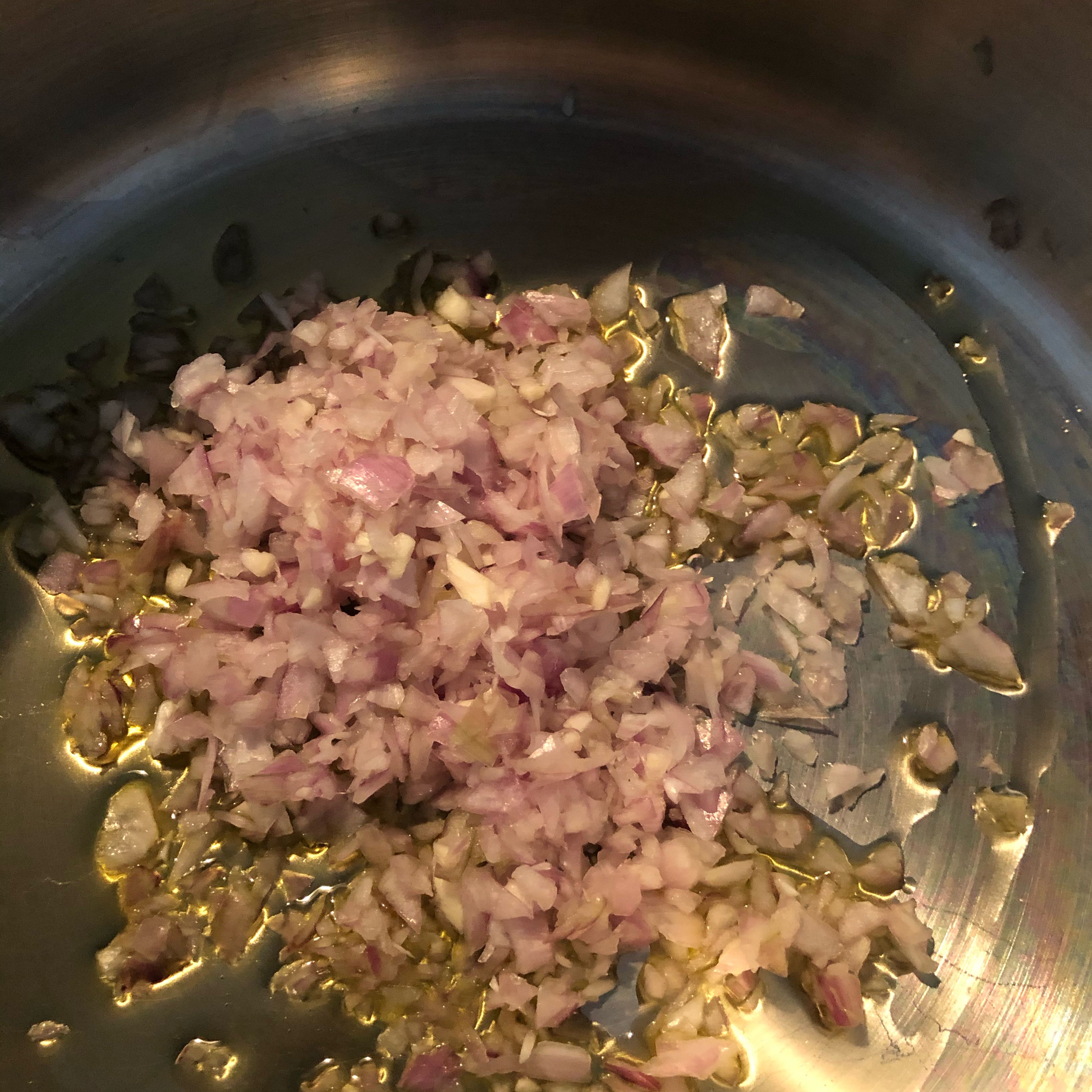 Die Schalotten und den Knoblauch in Olivenöl anschwitzen. Danach den Kohlenkohl und die Kartoffeln hinzufügen und einige Zeit anschwitzen, dabei ab und an umrühren. Nach etwa 5 Minuten mit etwa 2/3 des Weißweins ablöschen und aufkochen lassen. Danach auch die Gemüsebrühe hinzufügen