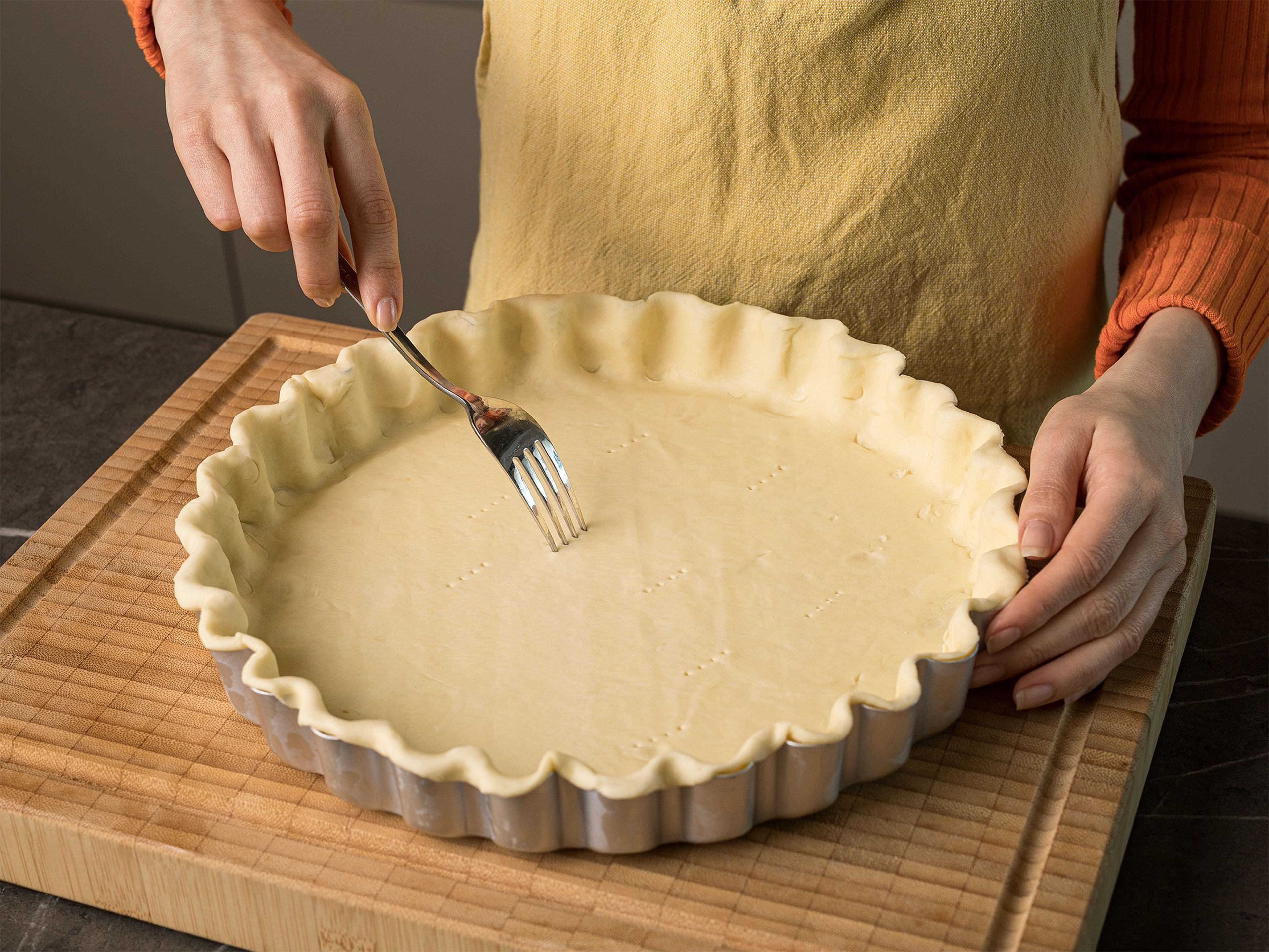Preheat oven to 200°C/392°F (180°C/356°F for convection oven). Lightly grease a tart pan (approx. 28 cm/11 in.) with oil. Place the dough in the tart pan and press down the dough along the sides. Prick the bottom with a fork. Line the dough with parchment paper and pie weights, such as baking beans. Then blind-bake for approx. 20 min., then remove the parchment paper and baking beans and bake again for approx. 10 min.