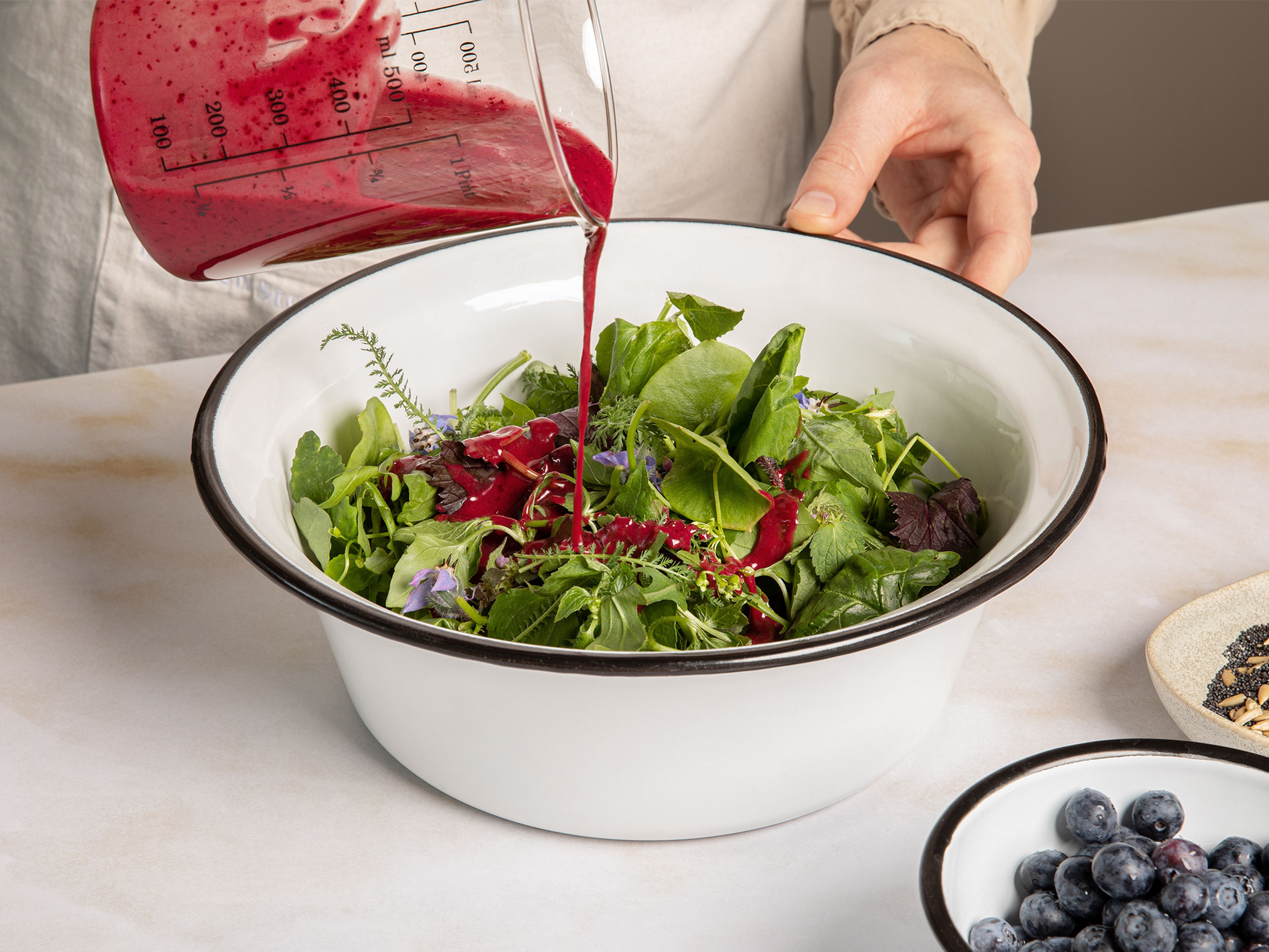 Toast the poppy seeds and sunflower seeds in a grease-free frying pan on medium heat and set aside to cool. Arrange the salad on the serving plate, drizzle the dressing. Top with the mozzarella,  the remaining blueberries, and garnish with the roasted seeds.