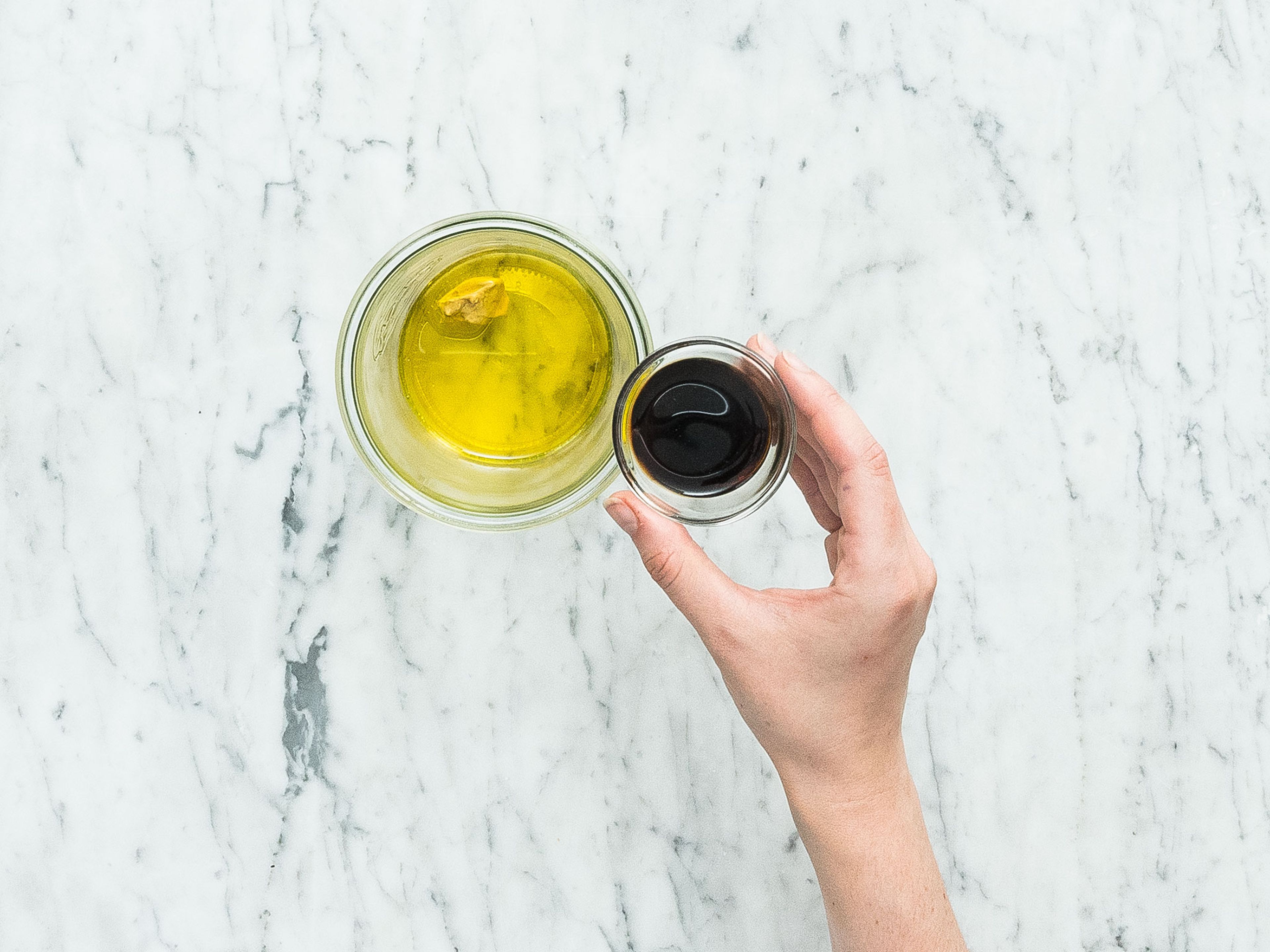 Für die Vinaigrette Weißweinessig, Balsamicoessig, Senf und Olivenöl direkt im Glas vermengen. Mit Salz und Pfeffer abschmecken.