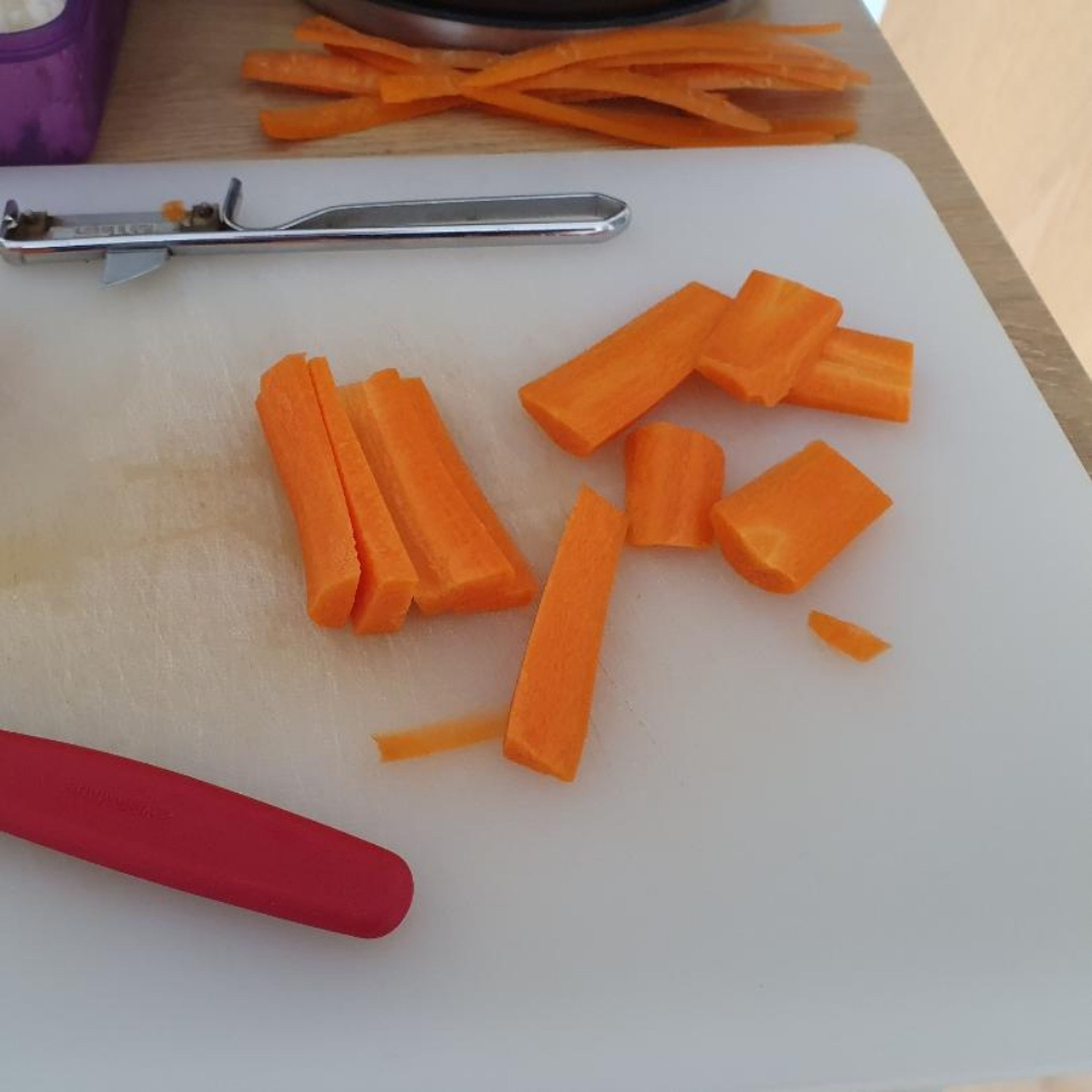 Karotte schälen, in etwa 5 cm lange Stücke schneiden. Diese in ca. 3 mm dicke Scheiben schneiden (Tipp: legt man die Karotte auf die geschnittene Seite, rutscht sie nicht so leicht weg :)).
