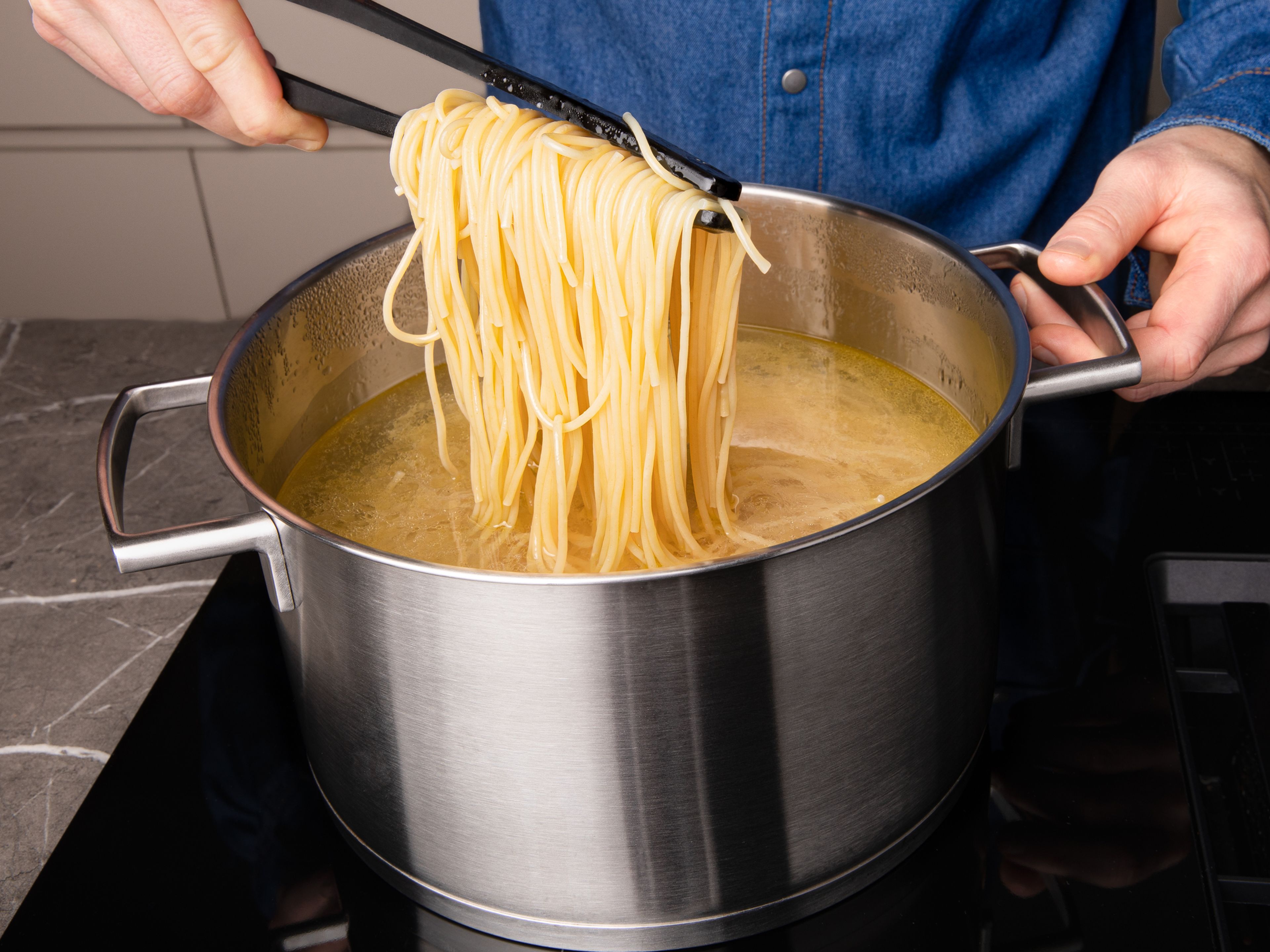 Gesalzenes Wasser in einem großen Topf zum Kochen bringen und die Spaghetti nach Packungsanleitung al dente kochen.