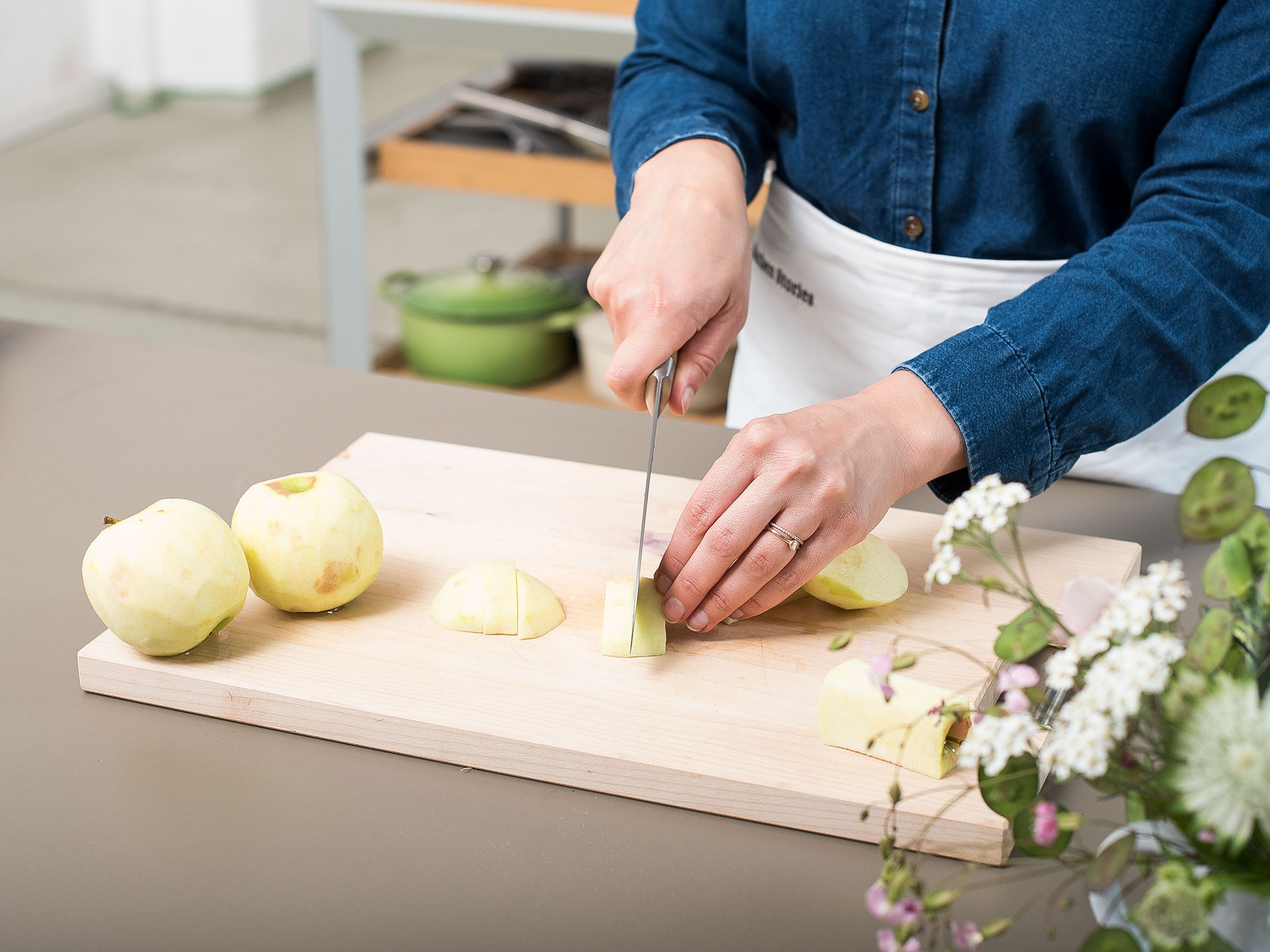 Backofen auf 180°C vorheizen. Backblech mit Backpapier auslegen oder einfetten und mit Mehl bestäuben. Äpfel schälen, entkernen und vierteln. Die Apfelviertel in dünne Scheiben schneiden und in einer großen Schüssel mit Zitronensaft vermengen. Anschließend beiseitestellen.