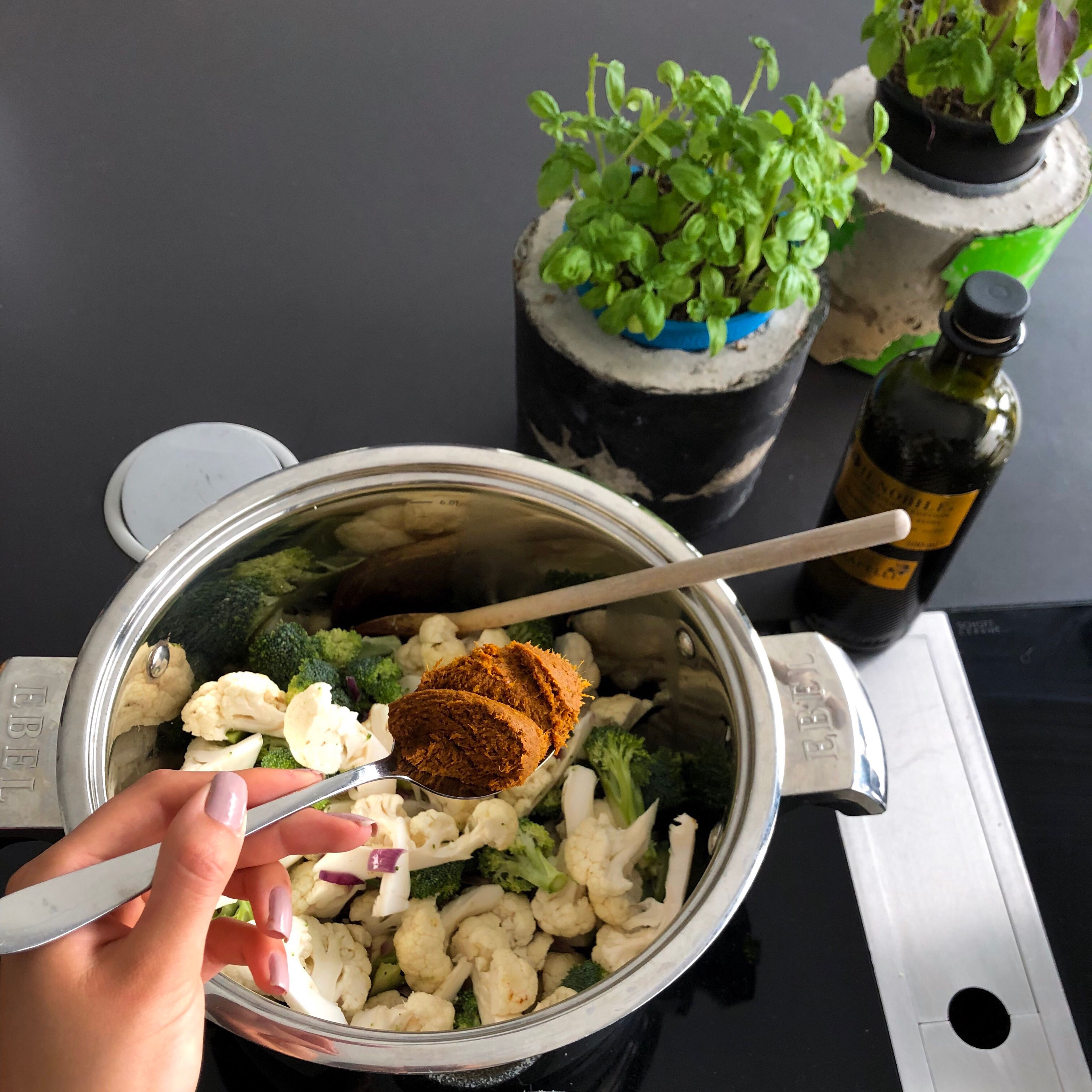 Blumenkohl, Brokkoli und Currypaste zu den Zwiebeln hinzufügen und für ca 5 Minuten mit dünsten. Je nach gewünschter Schärfe kann man zwischen roter und gelber Currypaste wählen.