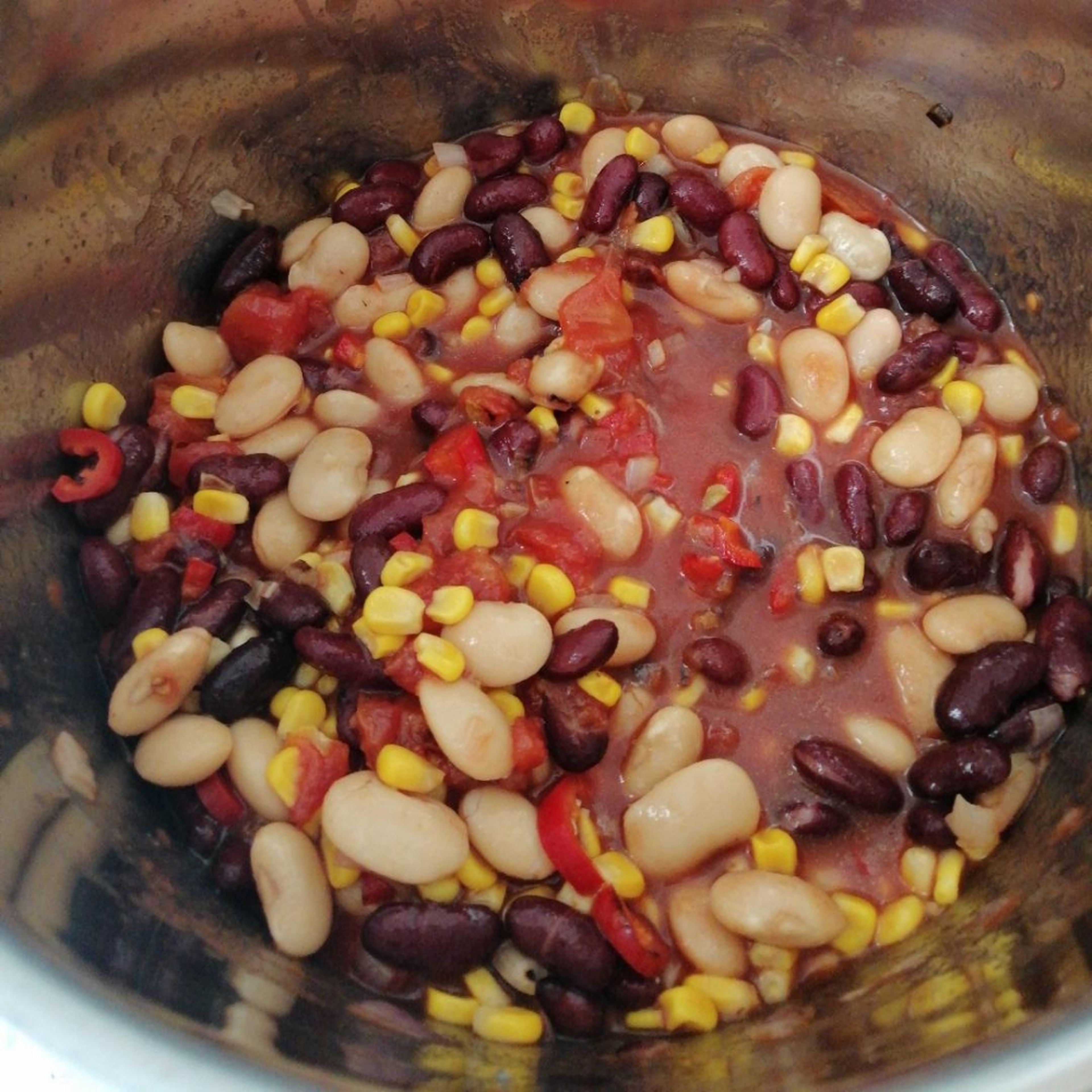 Bohnen, Mais und Tomaten in den Topf geben und ca. 5 Minuten auf niedriger Hitze köcheln lassen