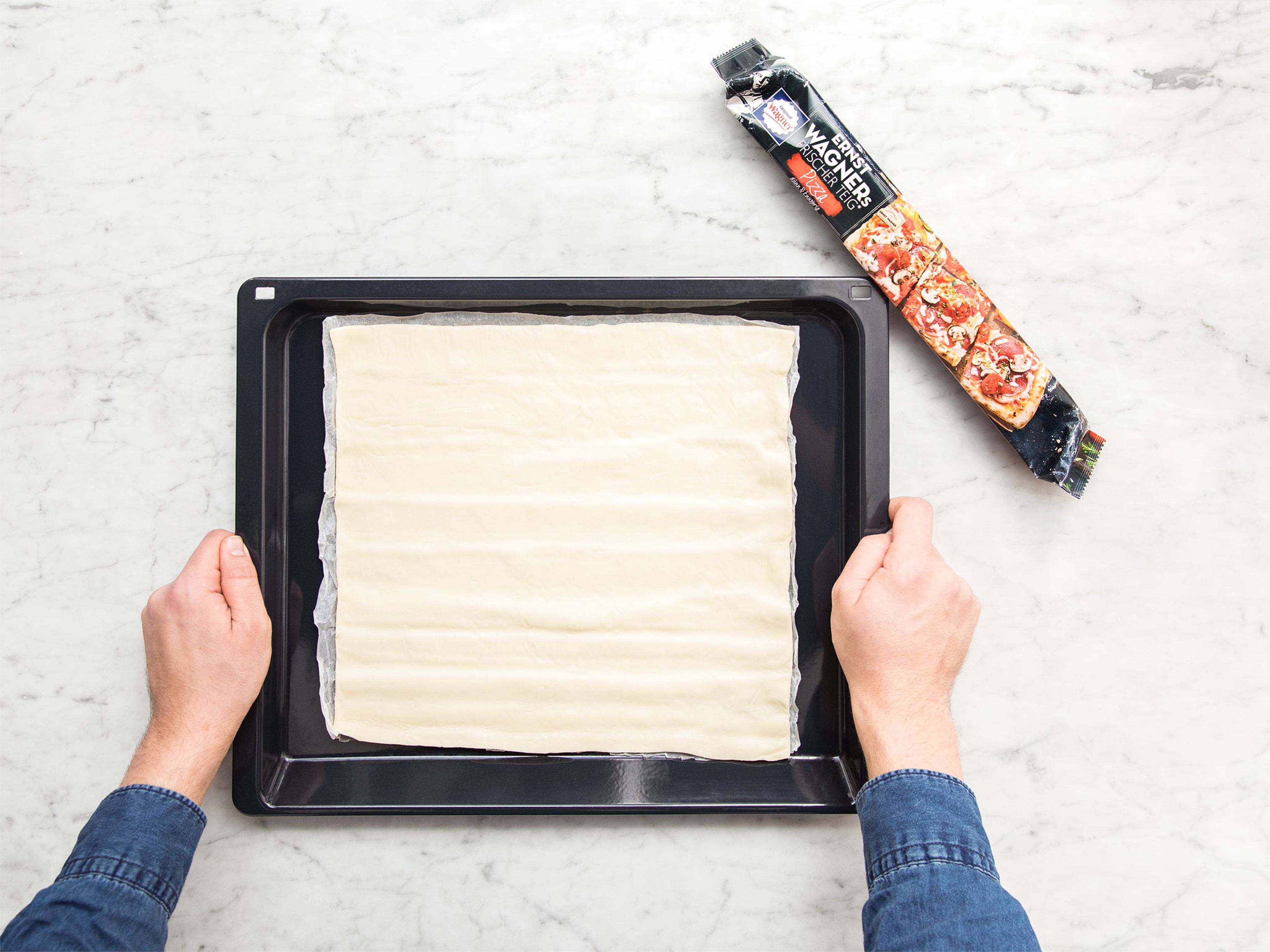 Preheat the oven to 210°C/410°F convection heat. Unfold pizza dough, transfer onto a baking sheet and pierce with a fork. Bake in the oven without any toppings for approx. 8 min., or until browned.