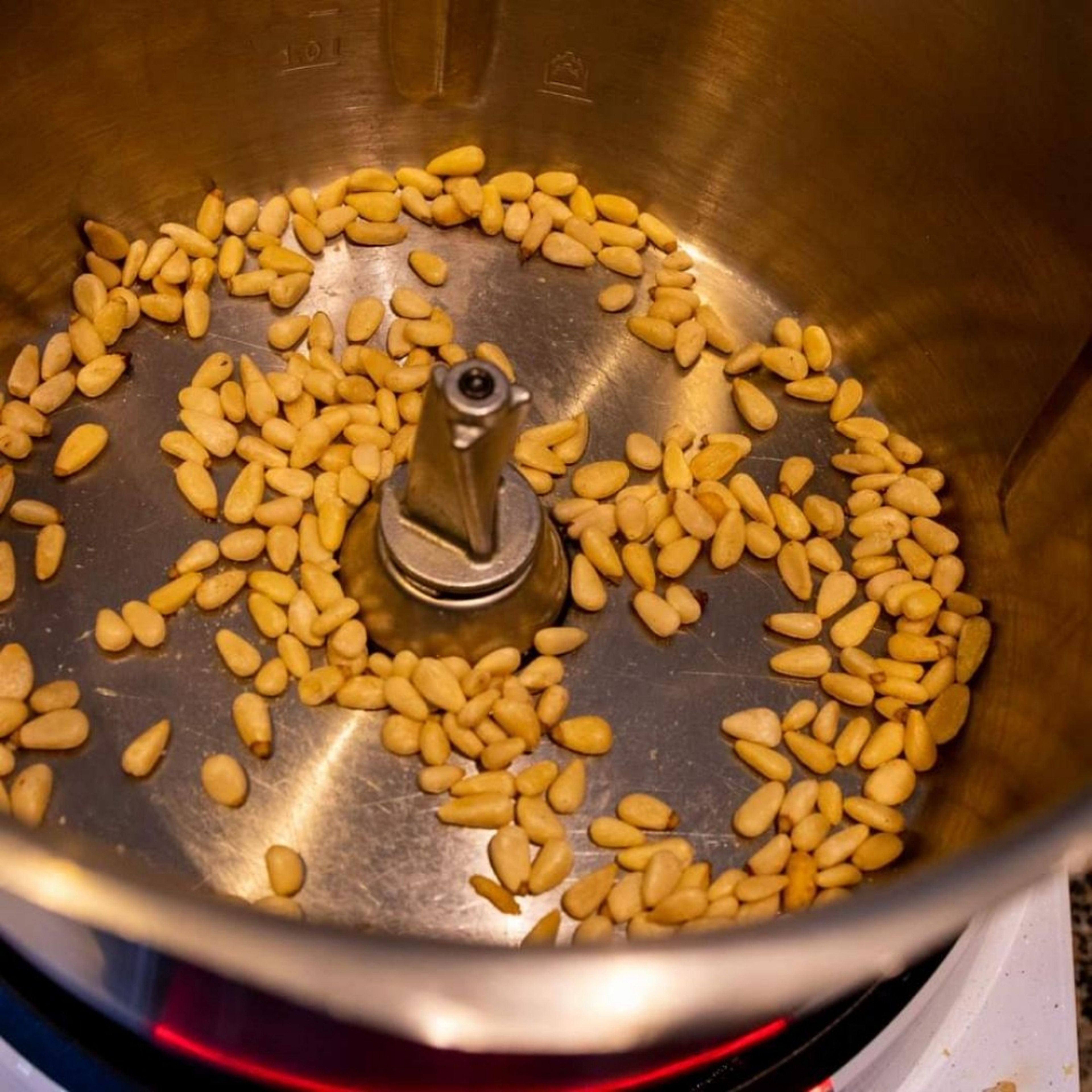 Pinienkerne oder Saaten in den Cookittopf geben und hellbraun ohne Fett bei 100 Grad ca. fünf Minuten unter Rühren anrösten. (Erdnüsse sind bereits geröstet). Pinienkernen oder Saaten aus dem Topf nehmen und zur Seite stellen