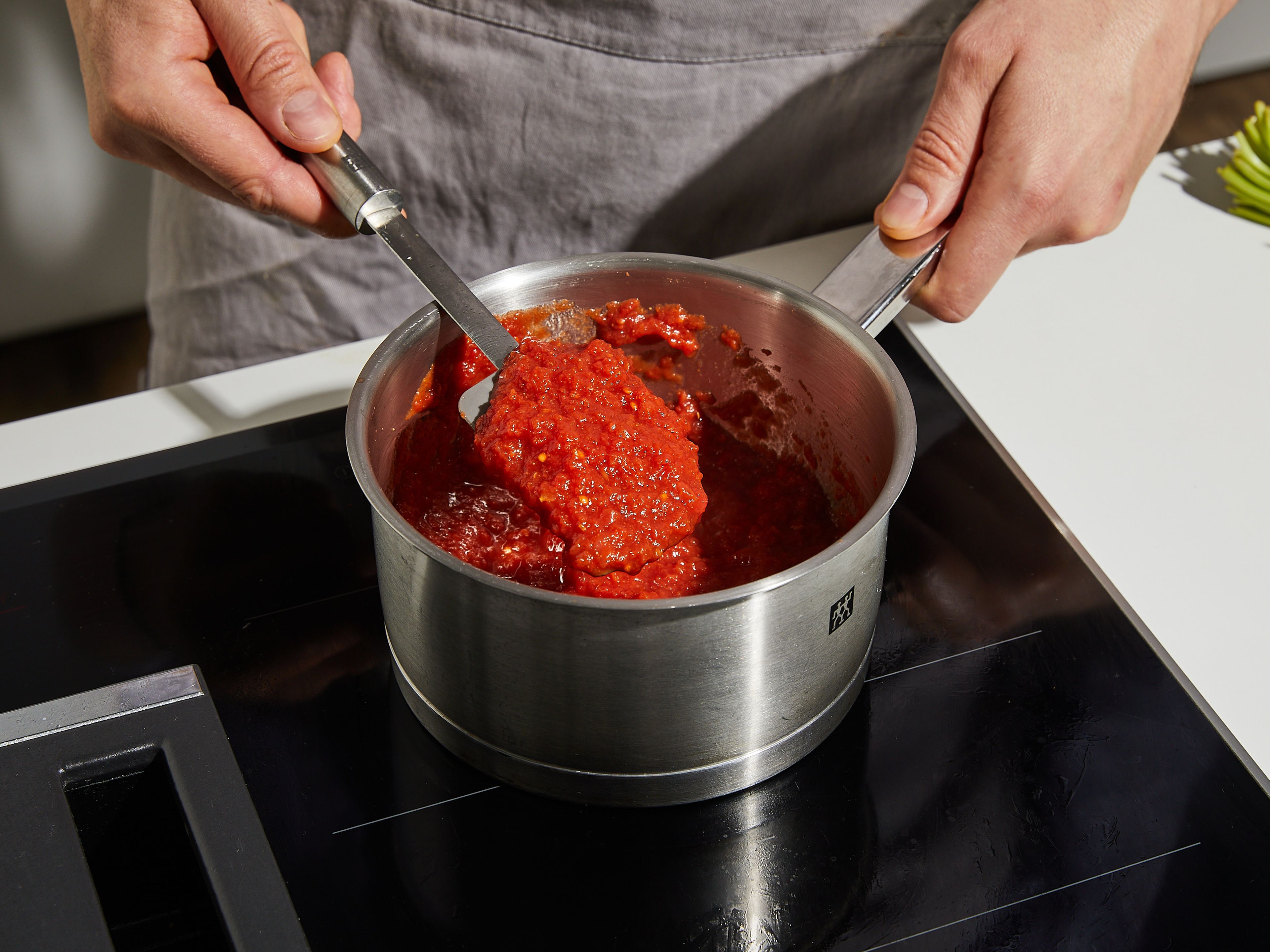 Für die Enchilada-Sauce in einem kleinen Topf Tomaten aus der Dose, Chilipulver, geräucherten Paprika, Kreuzkümmel und Gemüsebrühe vermengen. Mit Salz und Pfeffer abschmecken. Zum Köcheln bringen und ca. 8–12 Min. kochen, bis die Sauce eingedickt ist. In der Zwischenzeit den Cheddarkäse reiben.