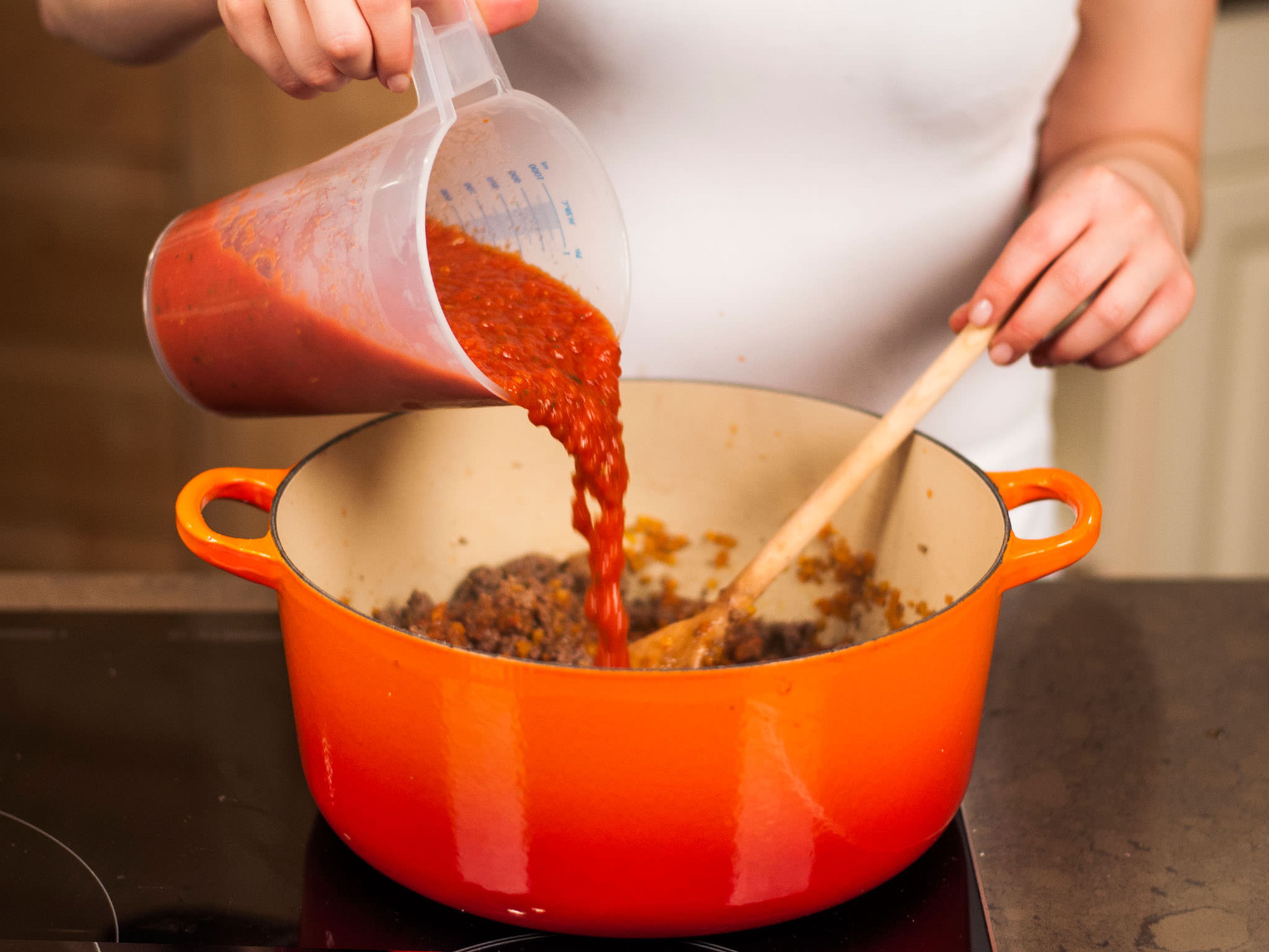 Tomaten hinzugeben. Mit Salz, Pfeffer und Oregano würzen. Offen bei mittlerer Hitze ca. 15 – 20 Min. köcheln lassen.