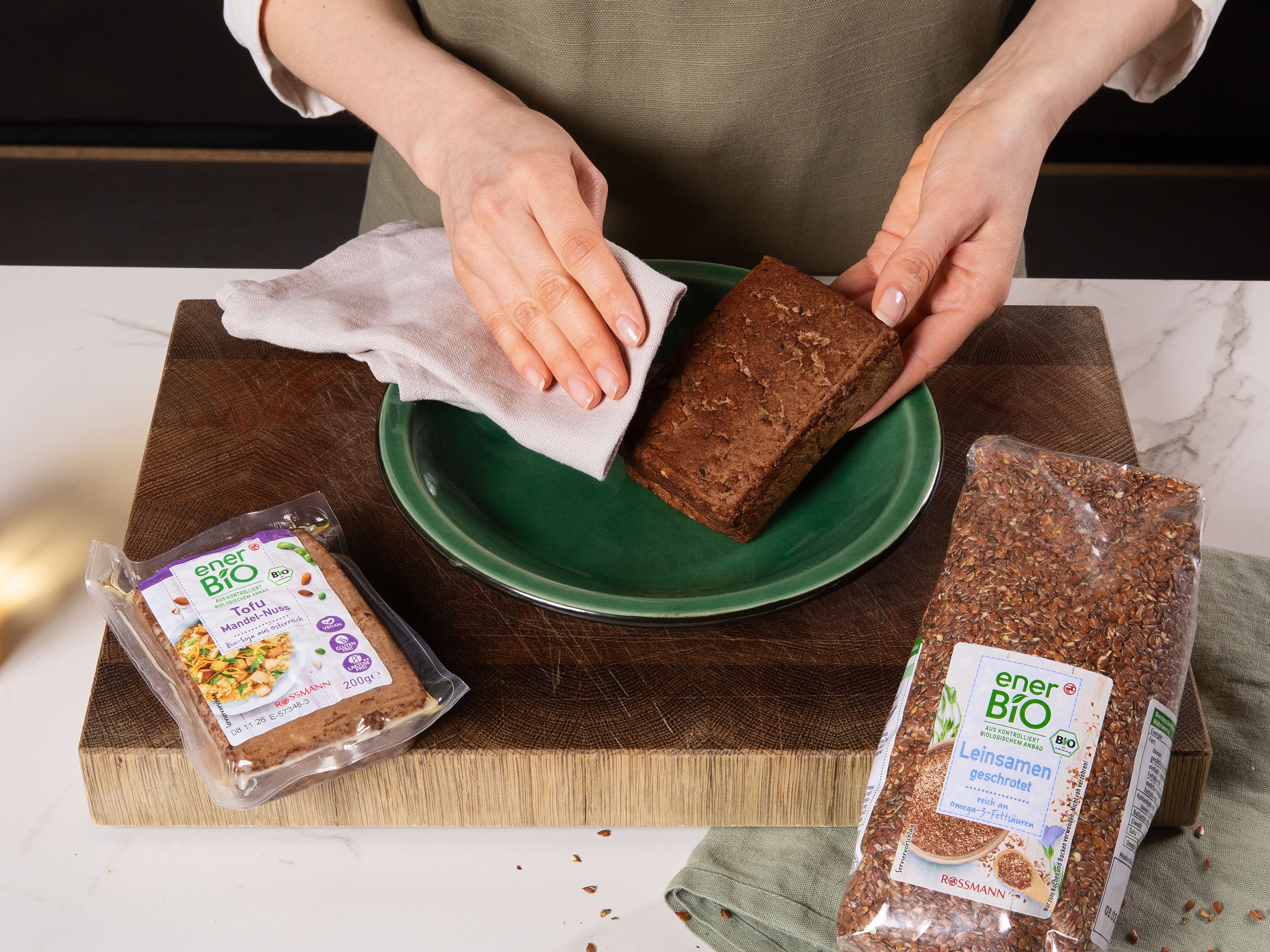Während das Gemüse röstet, den enerBiO Mandel-Nuss Tofu mit einem sauberen Küchentuch trocken tupfen und mit den Händen grob in eine Schüssel zerbröseln. Speisestärke und enerBiO geschrotete Leinsamen hinzufügen, mit Salz würzen und durchschwenken, bis alles gleichmäßig bedeckt ist. Öl in einer Pfanne erhitzen, den Tofu hineingeben und ca. 10 Min. braten. Dabei mit einem Holzlöffel umrühren, damit sich die Stücke auflockern und rundherum knusprig und braun werden. Den fertigen Tofu-Crumble auf einen Teller geben und beiseite stellen.