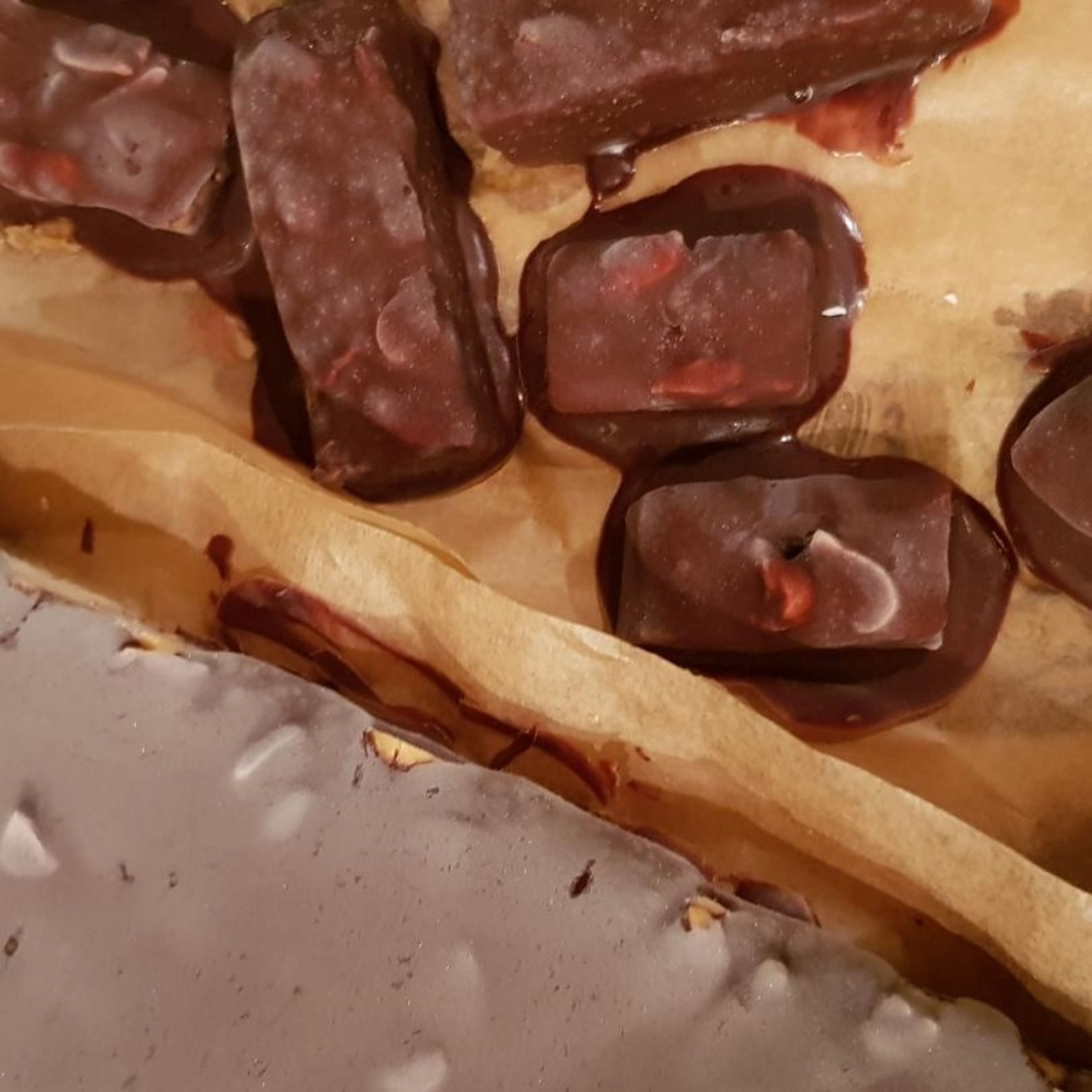 Die Schokolade Schmelzen und entweder darauf verteilen oder schon die geschnittenen Stücke in der Schokolade wenden.