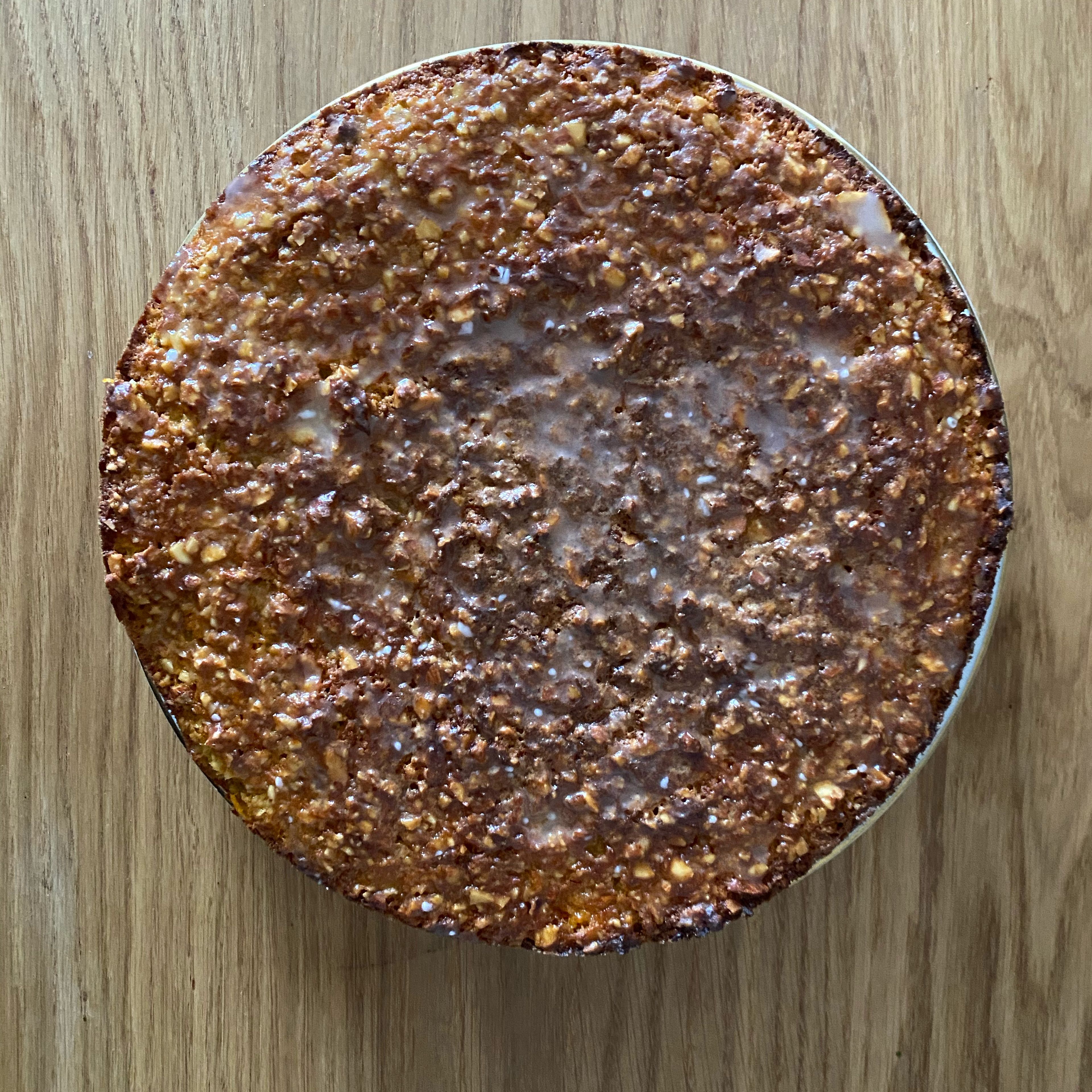 Den Kuchen aus dem Ofen holen und abkühlen lassen. Etwas Zitronensaft mit Puderzucker vermengen und den Kuchen damit glasieren. Wenn der Kuchen zu warm ist, wird die Glasur eingesogen, schmeckt aber auch. Bei einer erkalteten Oberfläche bleibt die Glasur als eigene Schicht bestehen.