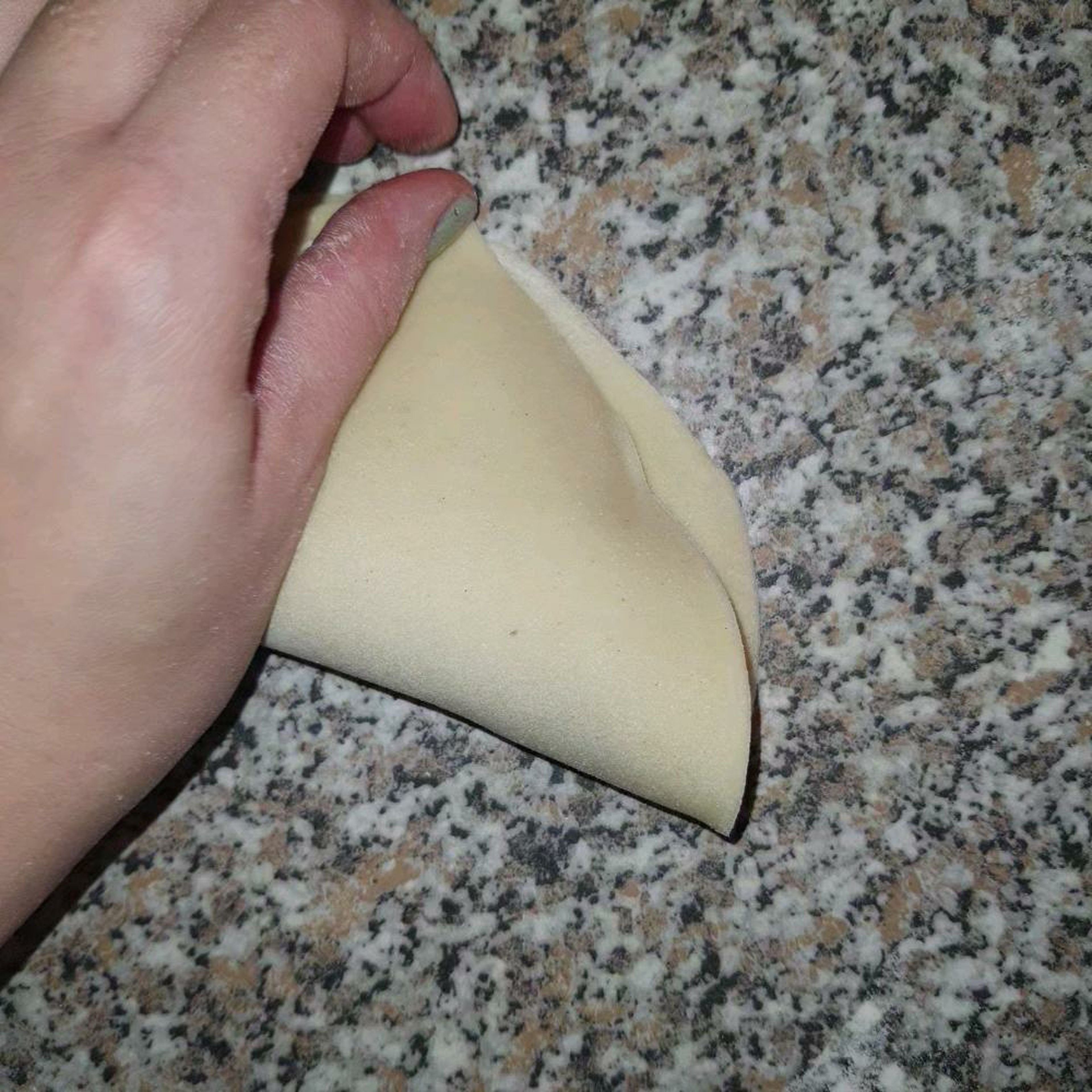Dritter Schritt wäre dann, Teig in vier Teile teilen. Es ist leichter auszurollen. Kreise ausstechen mit Topfdeckel ungefähr 16 oder 20 cm Durchmesser. Fleisch in die Mitte legen und streichen. Zu halb Mond schließen und mit der Gabel drücken damit alles zu ist. Das ist sehr wichtig.