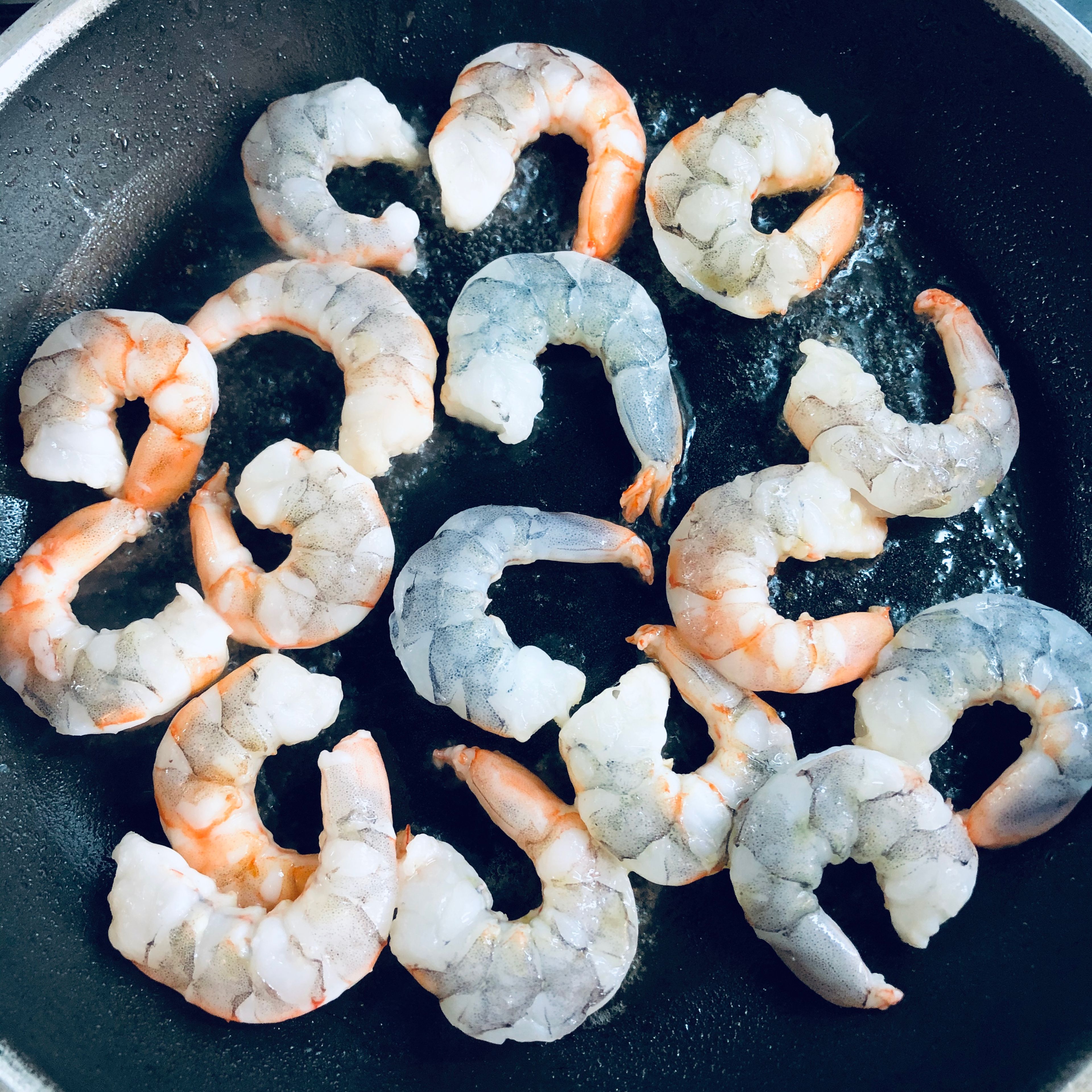 Place a frying pan on a medium heat, add the olive oil and when hot, add the prawns. Turn the heat up to high and fry the prawns a minute or two on each side until slightly browned and cooked through. Remove the prawns from the pan and set aside.