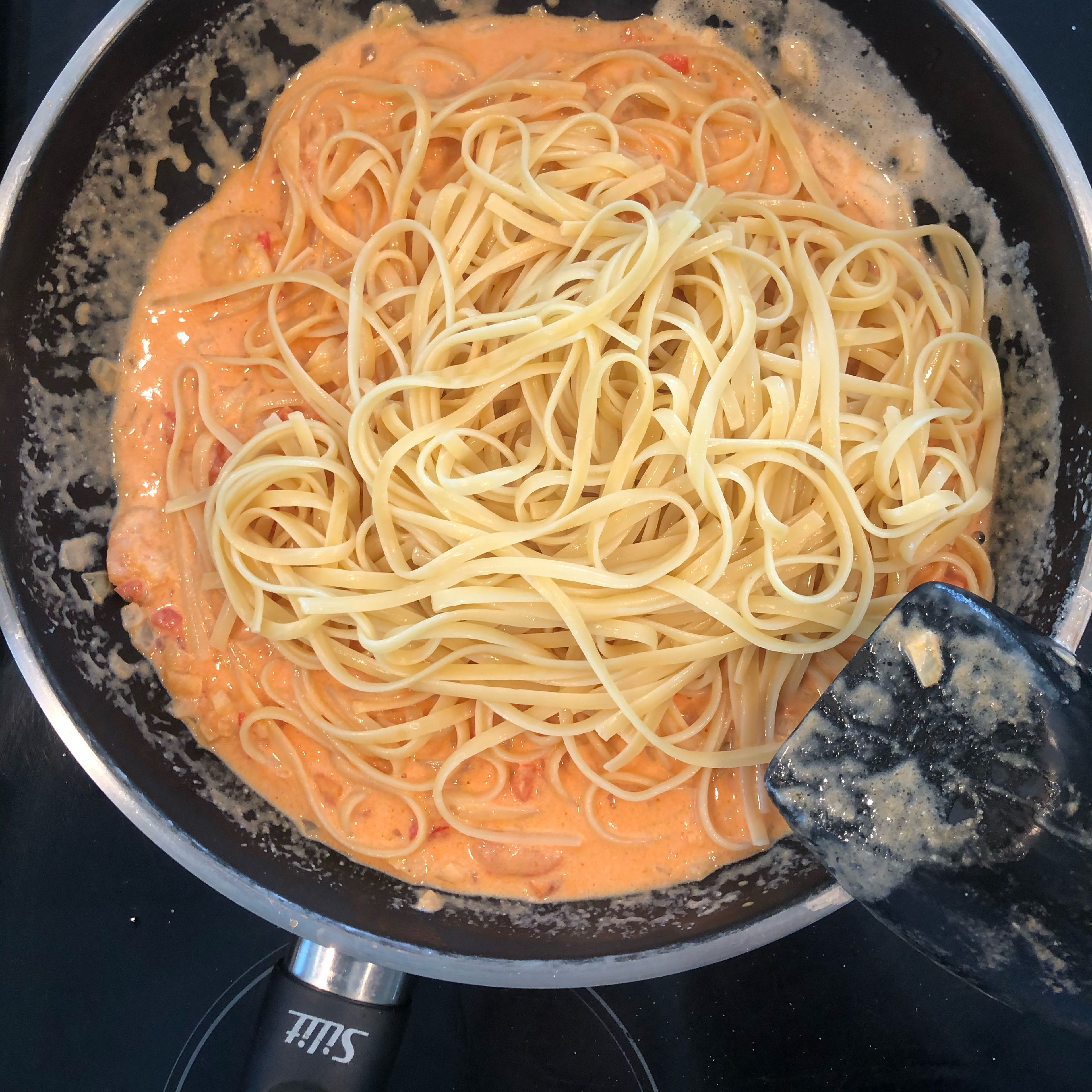 Die Spaghetti in die Pfanne geben, vermengen und mit Parmesan servieren!