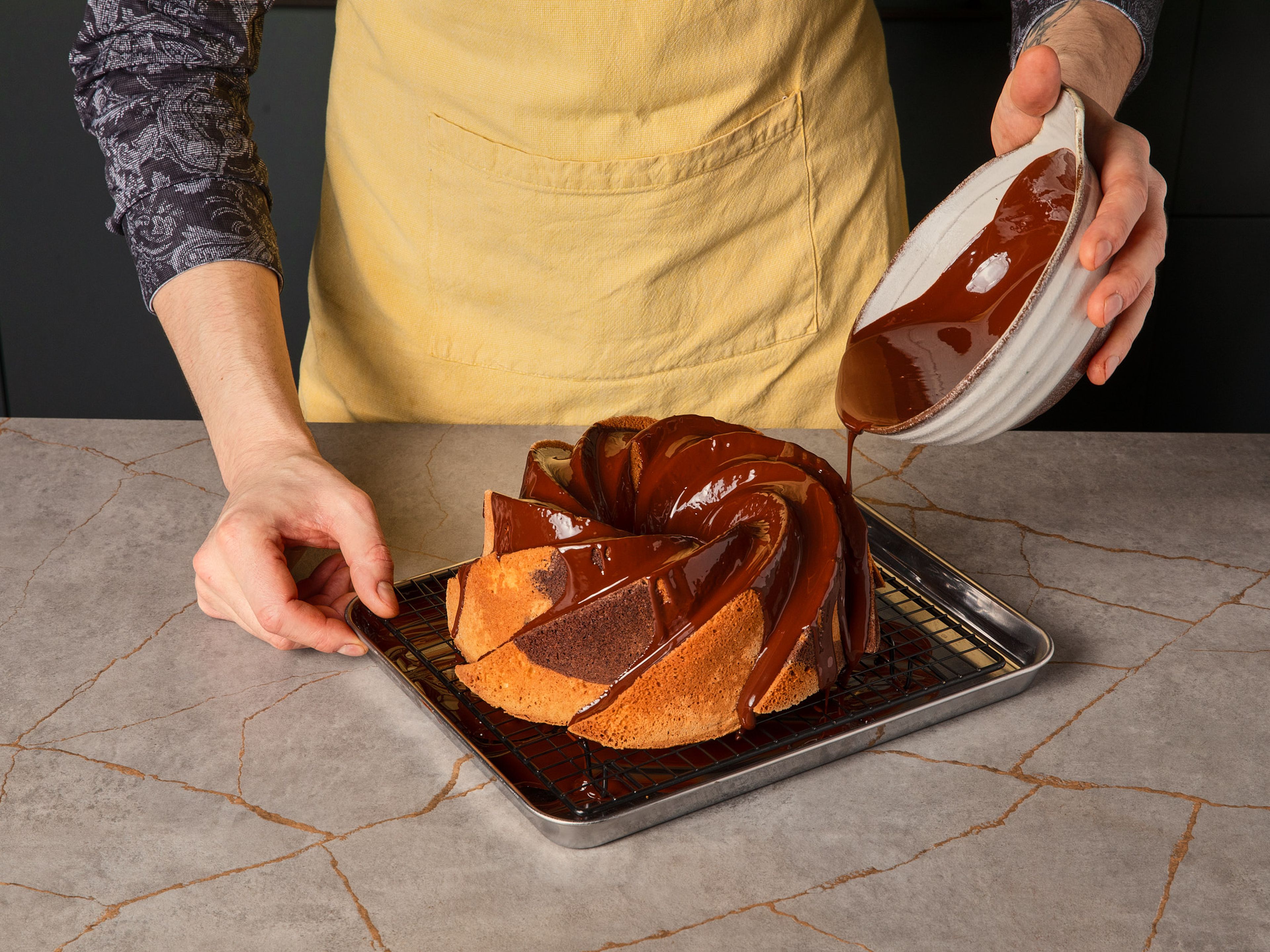 Sobald der Marmorkuchen abgekühlt ist, Butter und Schokolade in einem kleinen Topf bei niedrigster Hitze ca. 8–10 Min. schmelzen. Dabei regelmäßig umrühren, bis eine glatte Masse entsteht. Die Schokoglasur gleichmäßig über den Marmorkuchen geben und fest werden lassen. Sofort servieren oder bei Bedarf genießen.