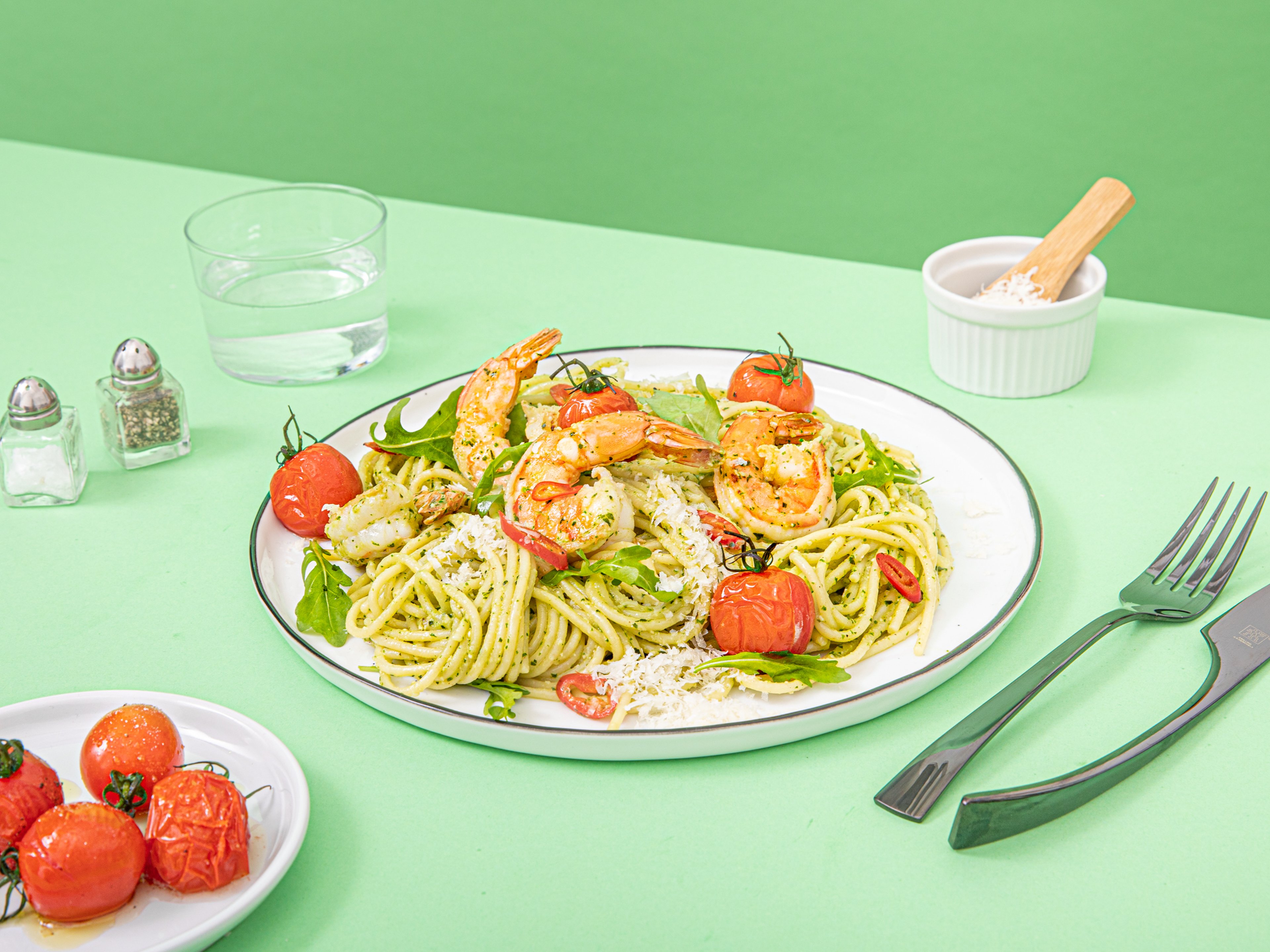 Pasta with arugula pesto, oven tomatoes, and spicy shrimp