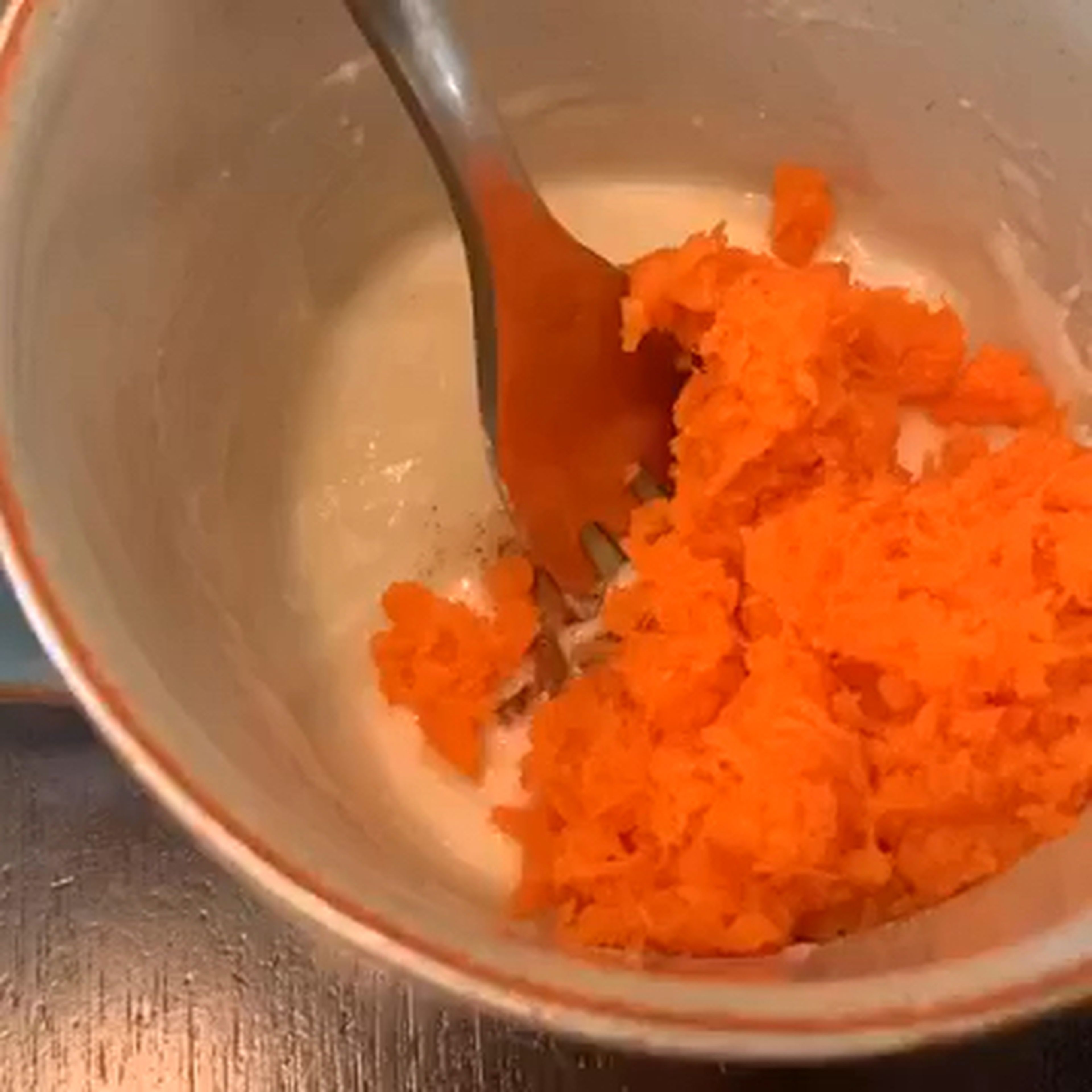 Add grated carrot, ground nutmeg, and cinnamon to the mug. Mix well and smooth it out.