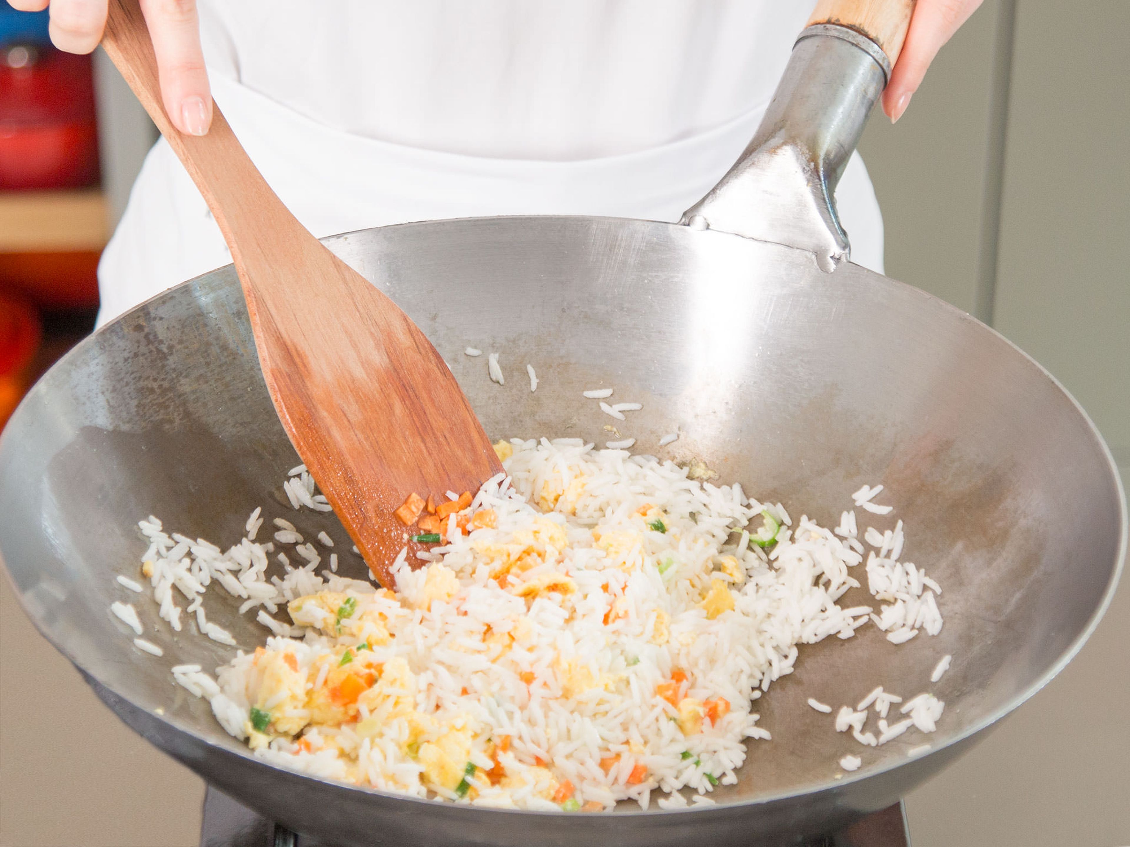 Add the cooked rice and diced carrot, season with salt, pepper, and wine, stir fry on highest heat.