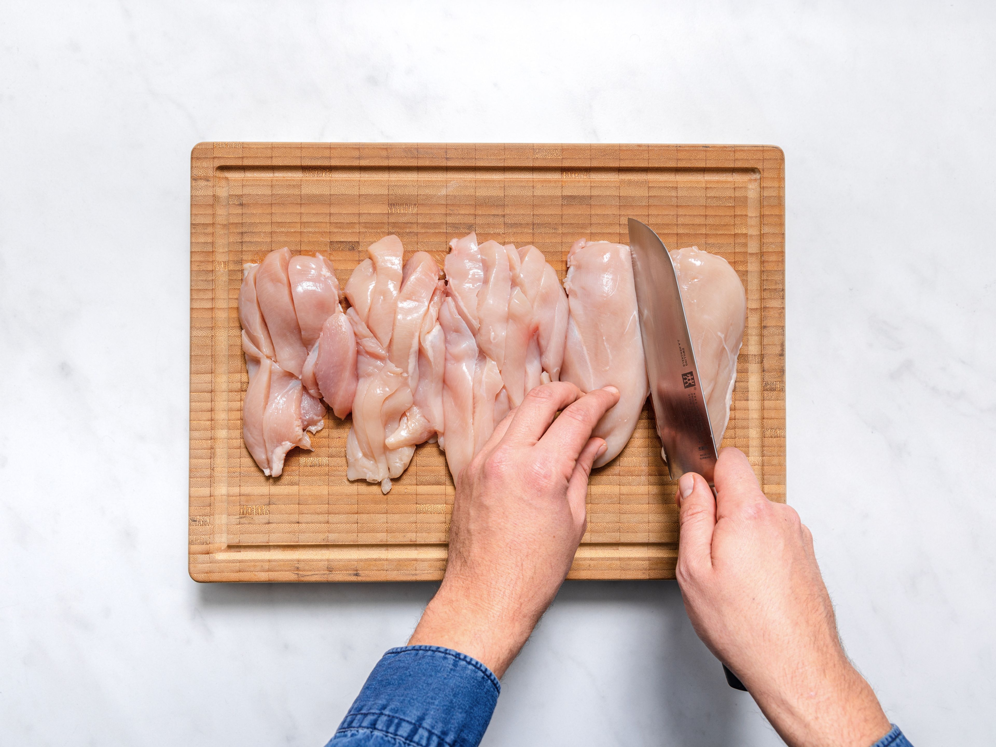 Den Ofen auf 200°C vorheizen. Die Hähnchenbrustfilets in Streifen schneiden. Das Panko Paniermehl gleichmäßig auf ein Backblech verteilen. Nun für ca. 3 – 5 Min. leicht goldbraun backen. Aus dem Ofen nehmen und vollständig abkühlen lassen.