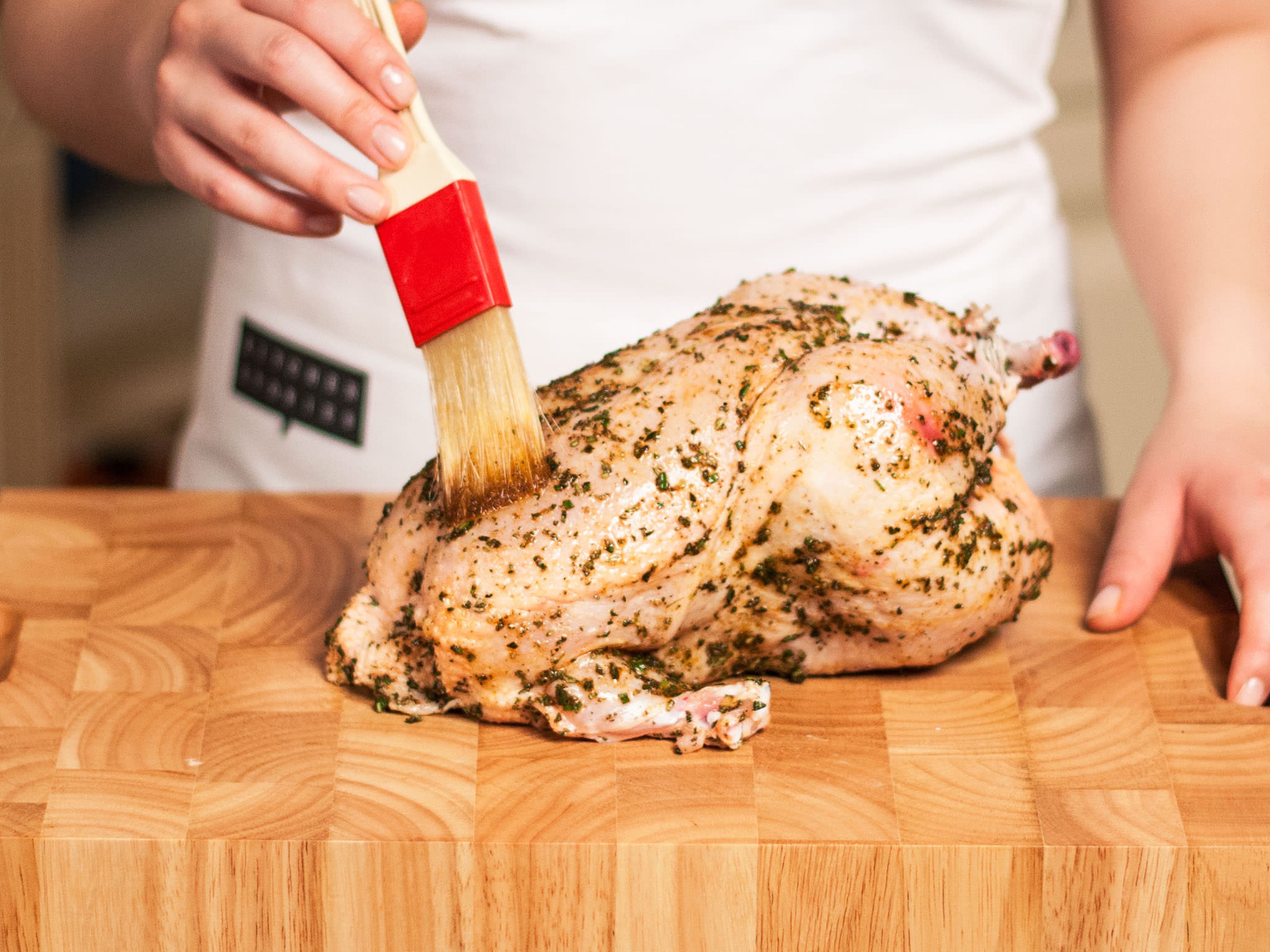 Brush chicken with the marinade on the inside and outside. Fill the cavity with previously marinated vegetables. Place chicken in a baking dish and arrange the remainder of the vegetables around the chicken.