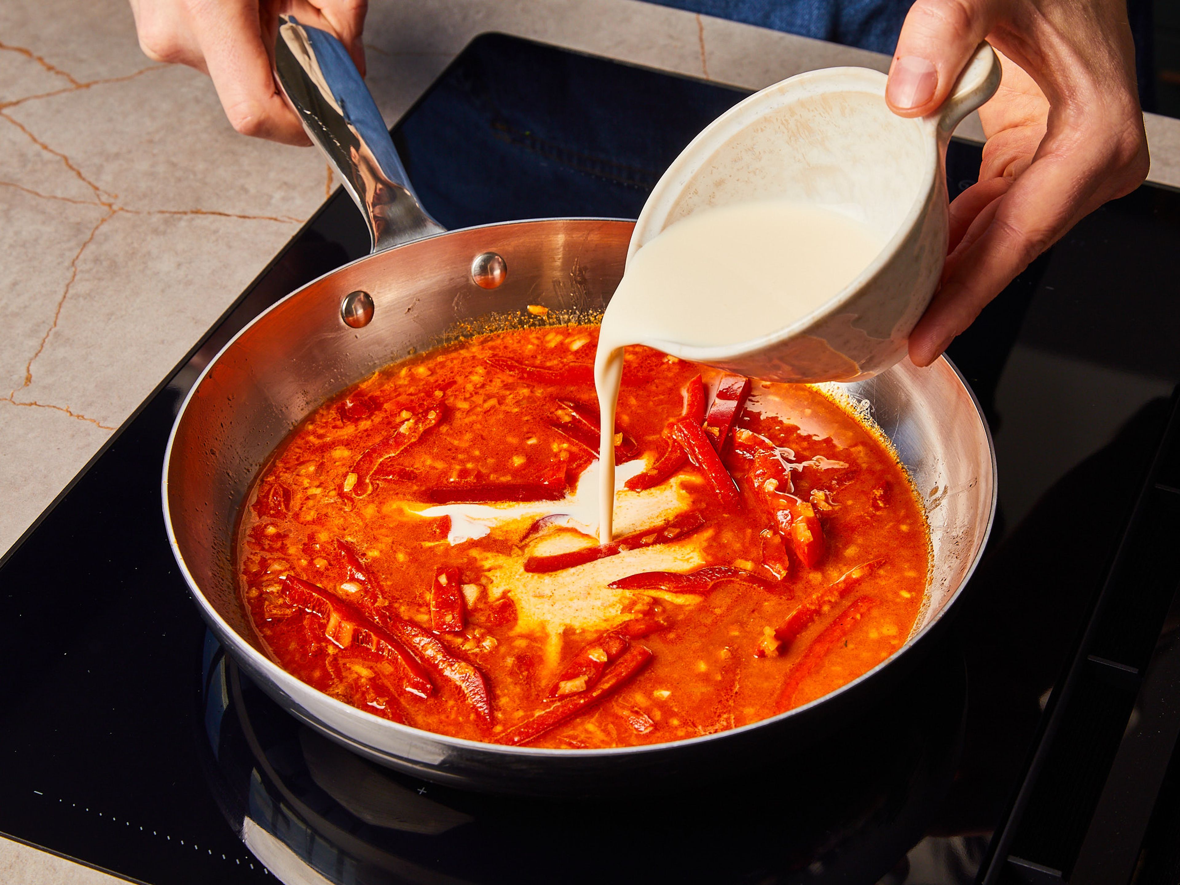 Add onion and pepper to the same pan and fry over medium heat for approx. 2 min. Add flour, sweet paprika, and spicy paprika. Then add chicken broth and cream. Bring everything to a simmer until a creamy sauce forms.