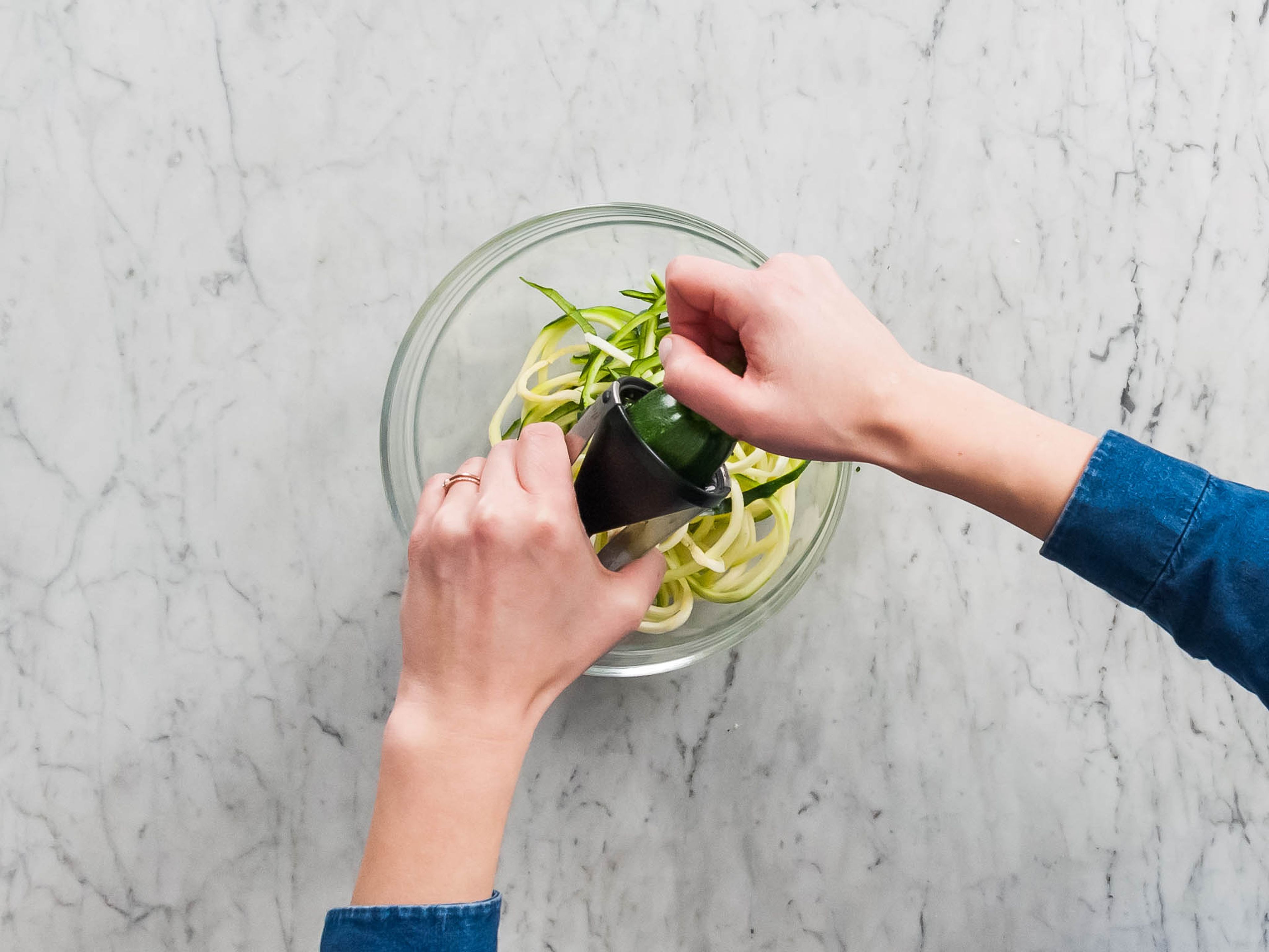 Using a vegetable spiralizer or peeler, cut whole zucchini into spaghetti-like noodles or ribbons.