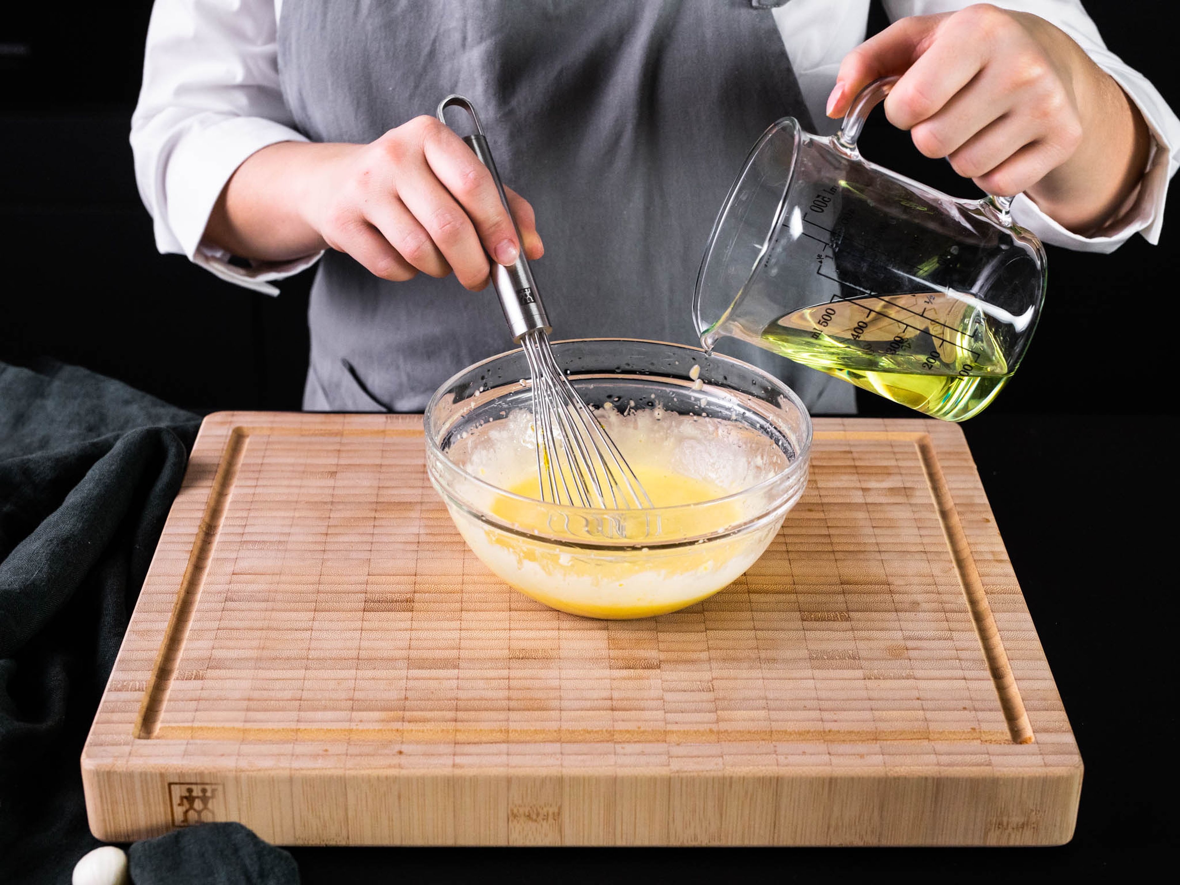 Eigelb, Zitronenabrieb und -saft, Senf und Salz in einer Schüssel verrühren. Pflanzenöl unter ständigem Rühren langsam dazugeben, bis eine homogene, glatte Mischung entsteht.