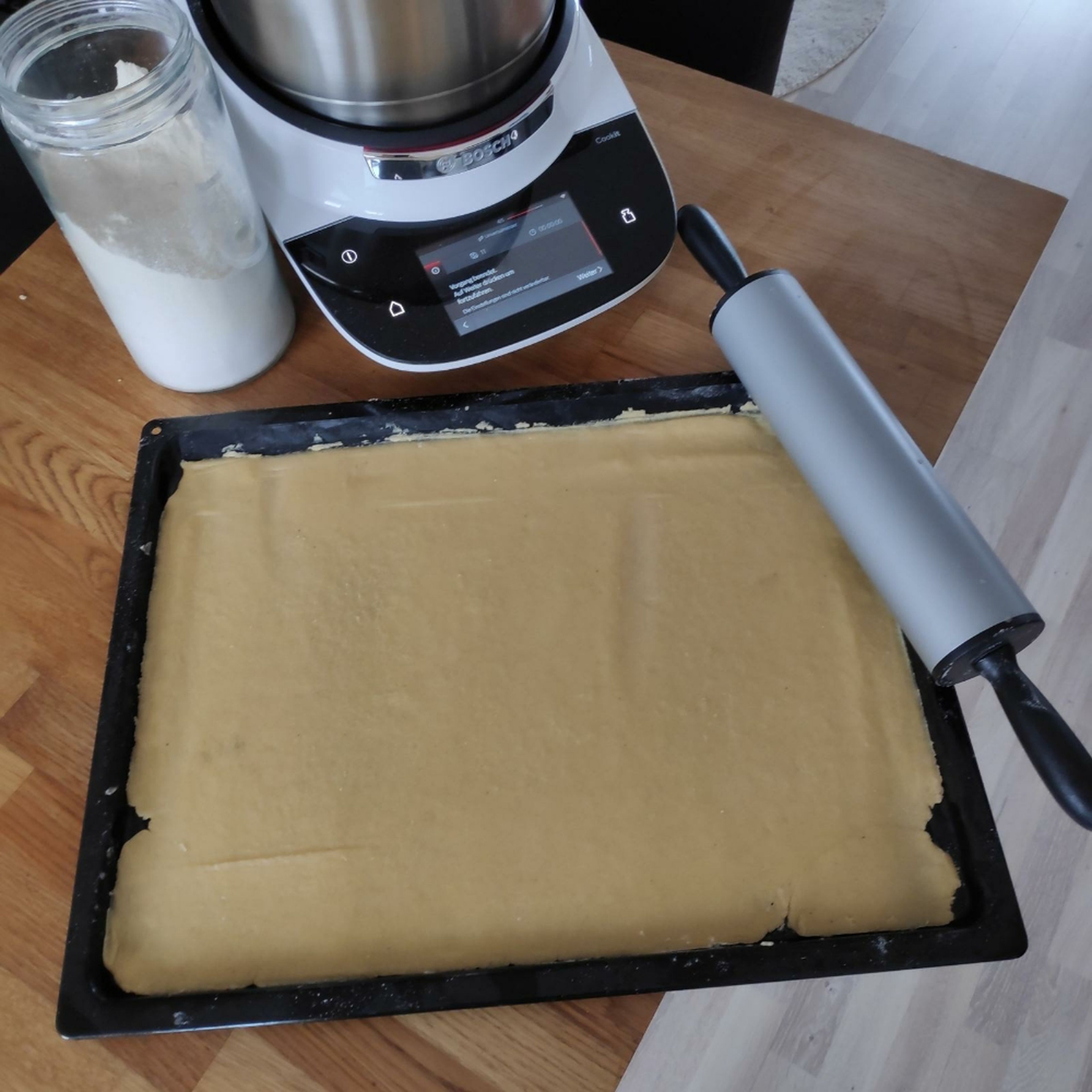 Den Teig aus dem Cookit nehmen und auf einem Backblech ausrollen. Anschließend im vorgeheizten Ofen bei 180°C für ca. 10 Minuten vorbacken und danach leicht abkühlen lassen. Universalmesser entnehmen und den Cookit grob reinigen.