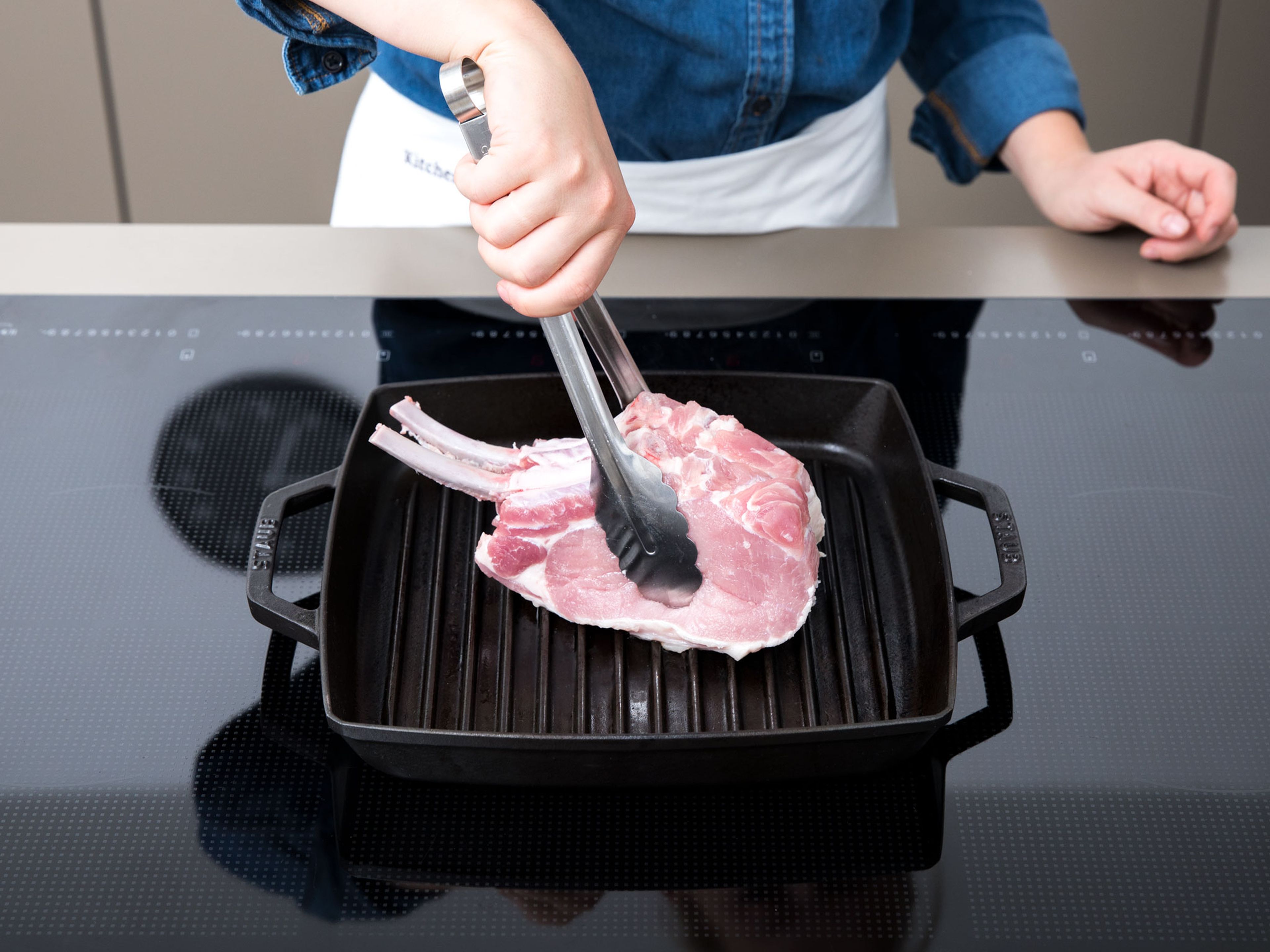 Schweinekoteletts von beiden Seiten salzen und in einer heißen Grillpfanne rundherum für ca. 10 Min. anbraten.