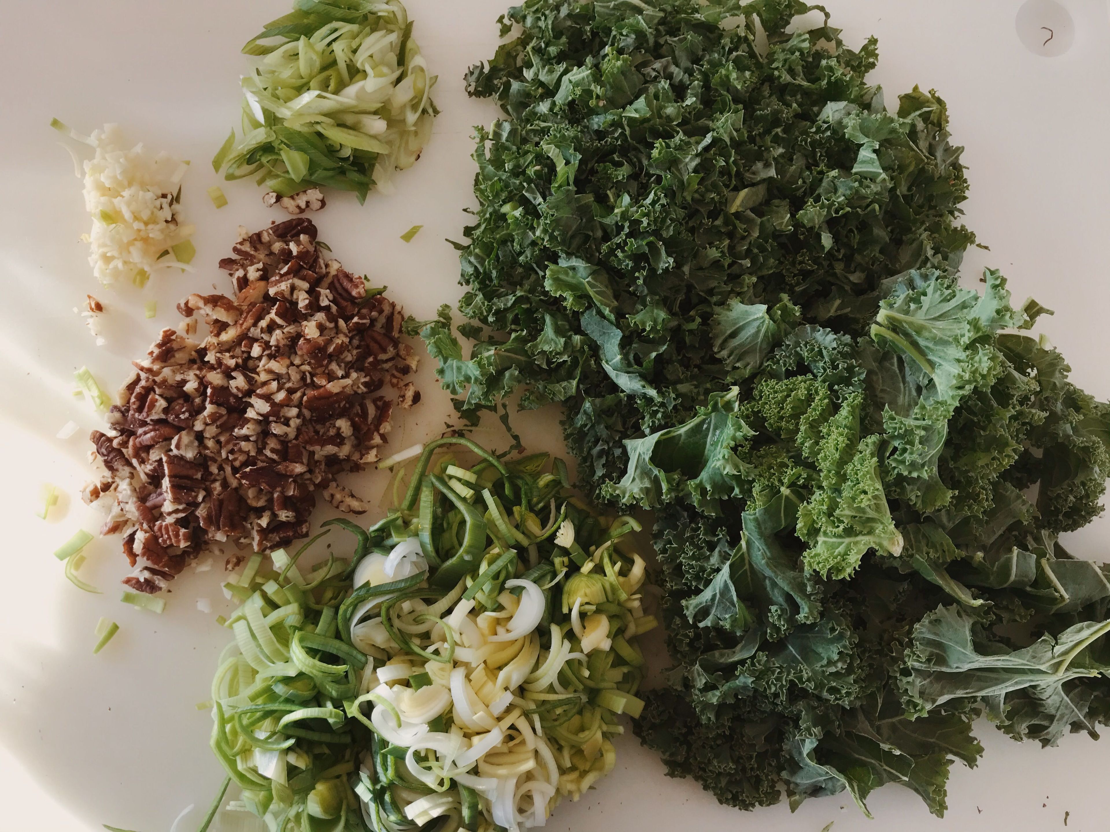 Pluck the kale leaves from the stems and cut into small pieces. Slice the leeks, finely chop the garlic and cut the spring onion into fine rings. Toast the pecans in a pan without fat and then chop them.