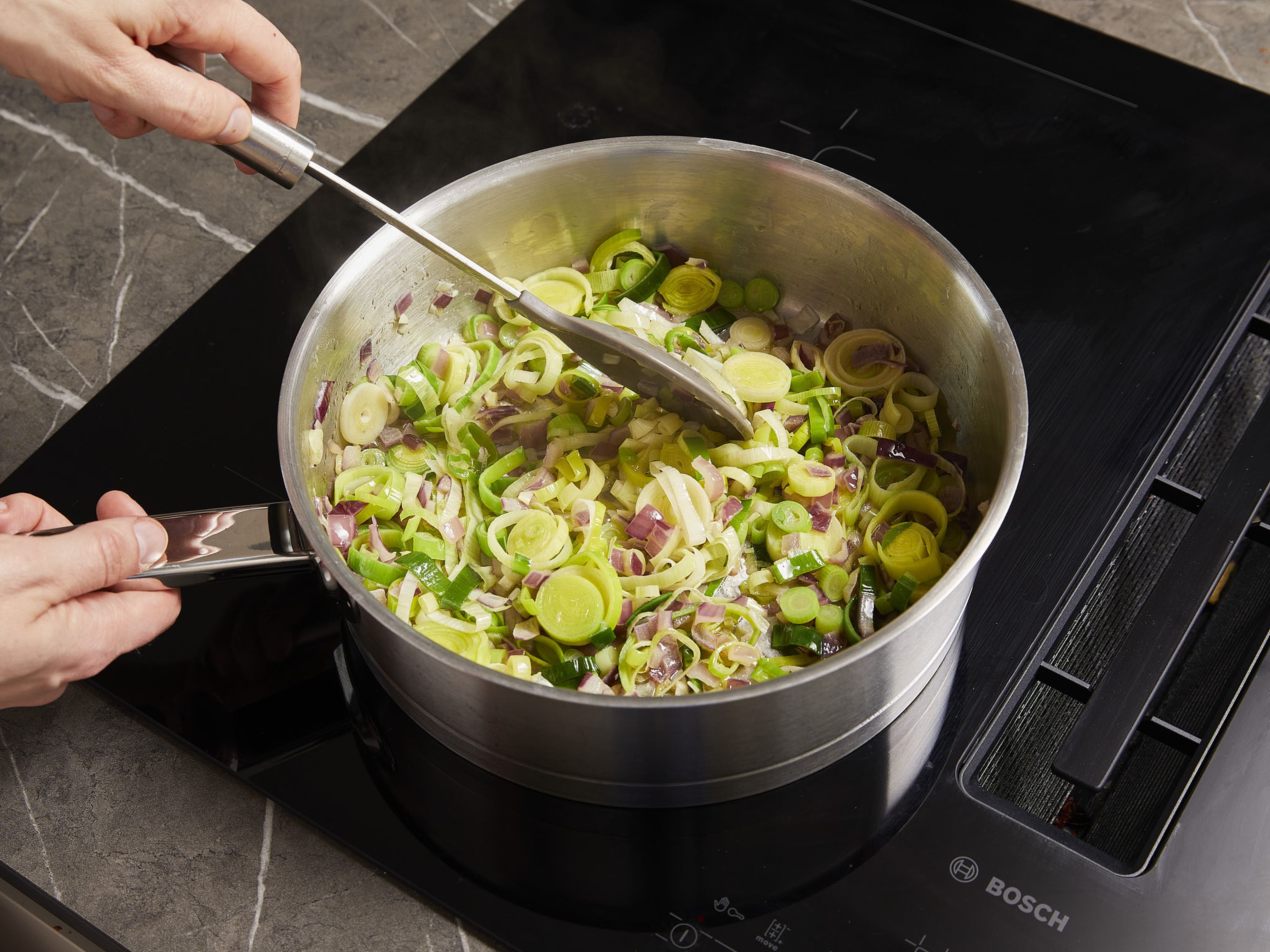 Preheat oven to 180°C/350ºF.  Cut scallions into fine rings. Separate the whites from the greens and put the latter aside for garnishing. Cut leek into fine rings. Dice onion and mince garlic. Rinse rice and drain. Heat butter in a deep frying pan. Fry onion, garlic, scallion whites, and leek over medium-high heat for approx. 3–5 min. until translucent. Season with salt. Then add flour and curry powder, and fry for approx. 1 more min.