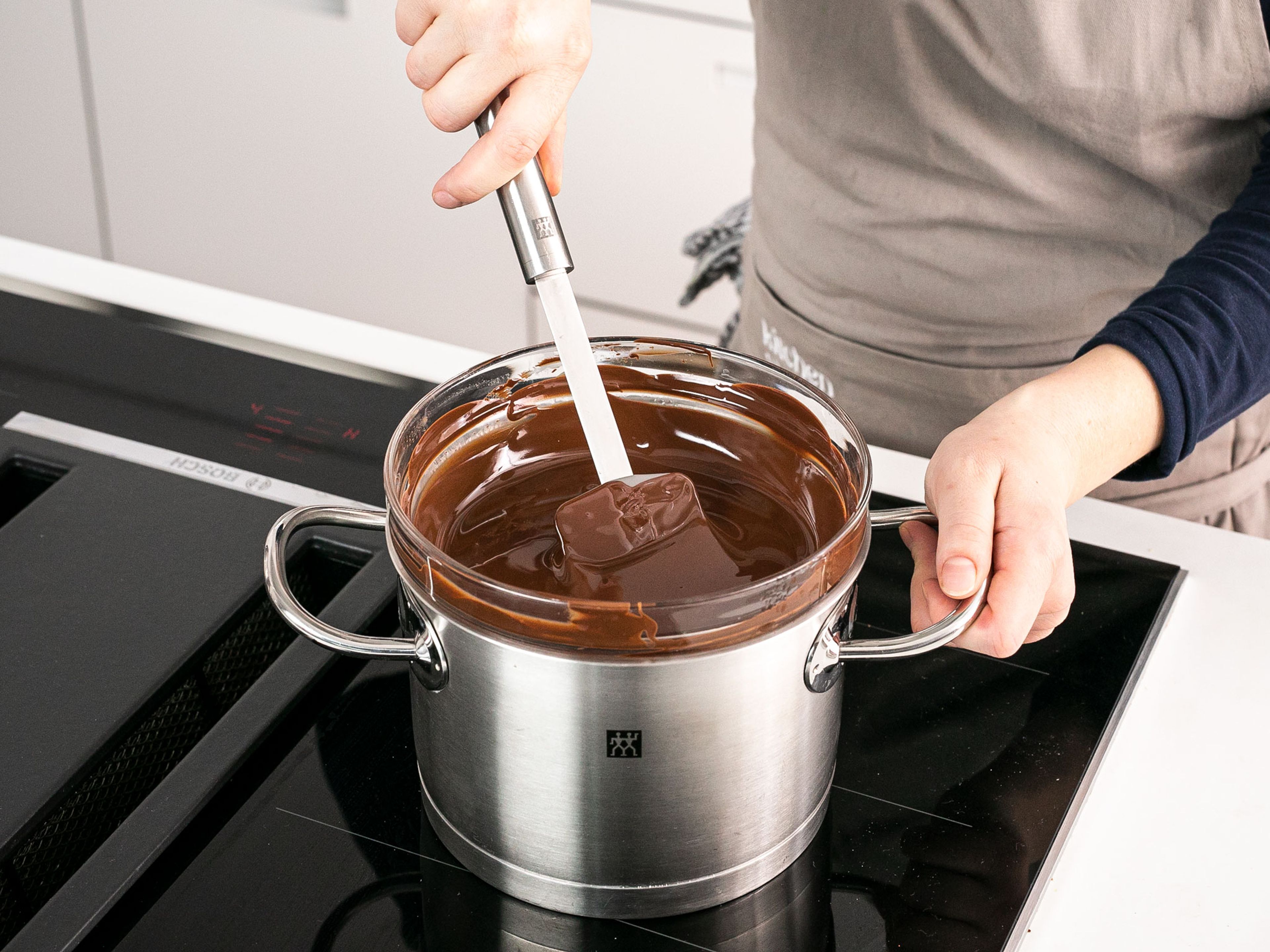 For the filling, melt chocolate in a heatproof bowl over a pot of simmering water. Once melted, remove from heat and mix in remaining butter, vanilla extract, cocoa powder, and powdered sugar until a homogeneous mixture forms. Let cool completely. For the glaze, heat remaining milk and sugar together until all the sugar dissolves, then set aside.