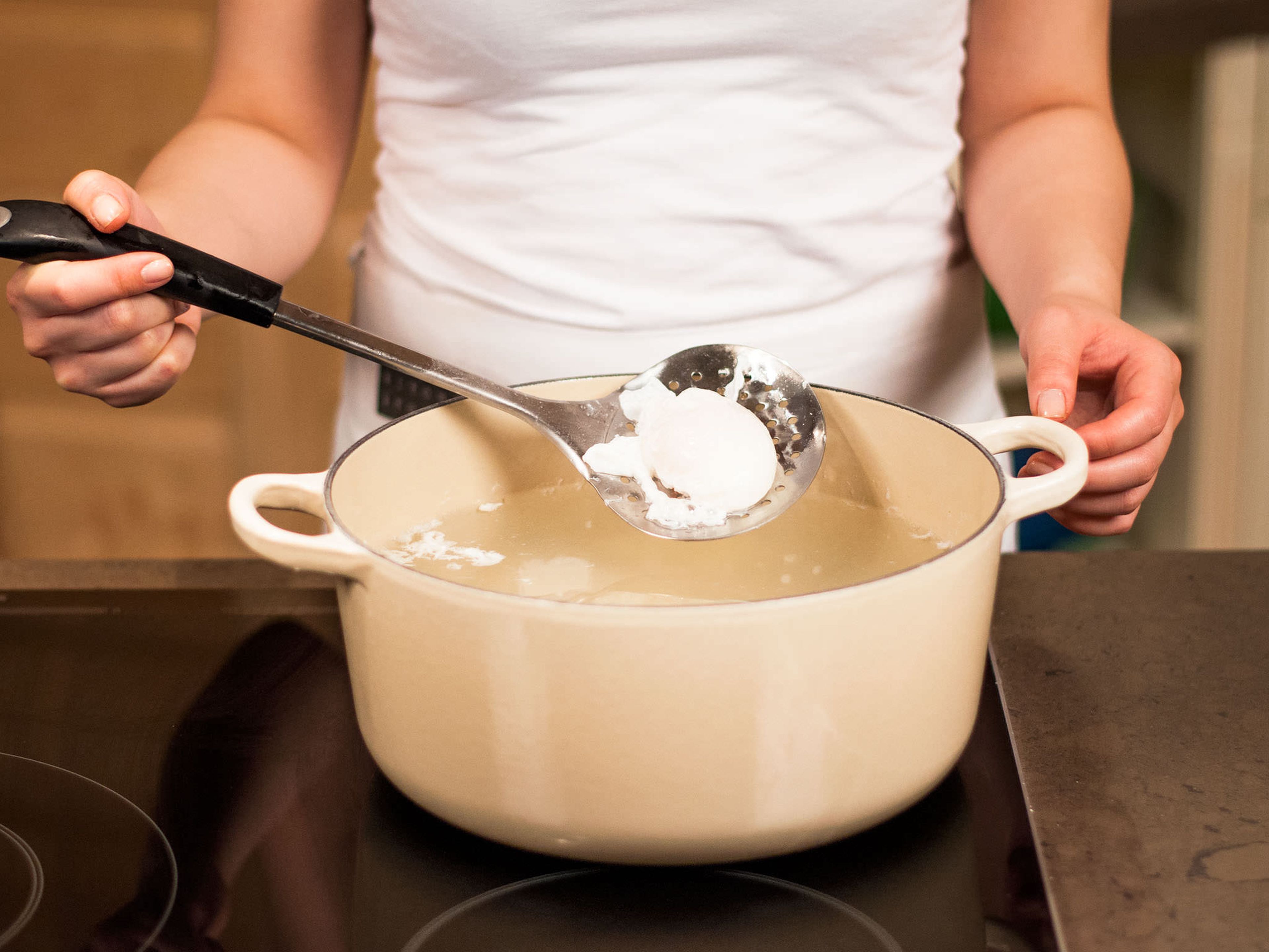 1 Liter Wasser in einem großen Topf erhitzen bis es köchelt. 2 EL Weißweinessig hinzufügen und Eier im Wasser für ca. 3 Min. pochieren. Nun auf einen mit Küchenpapier ausgelegten Teller legen.