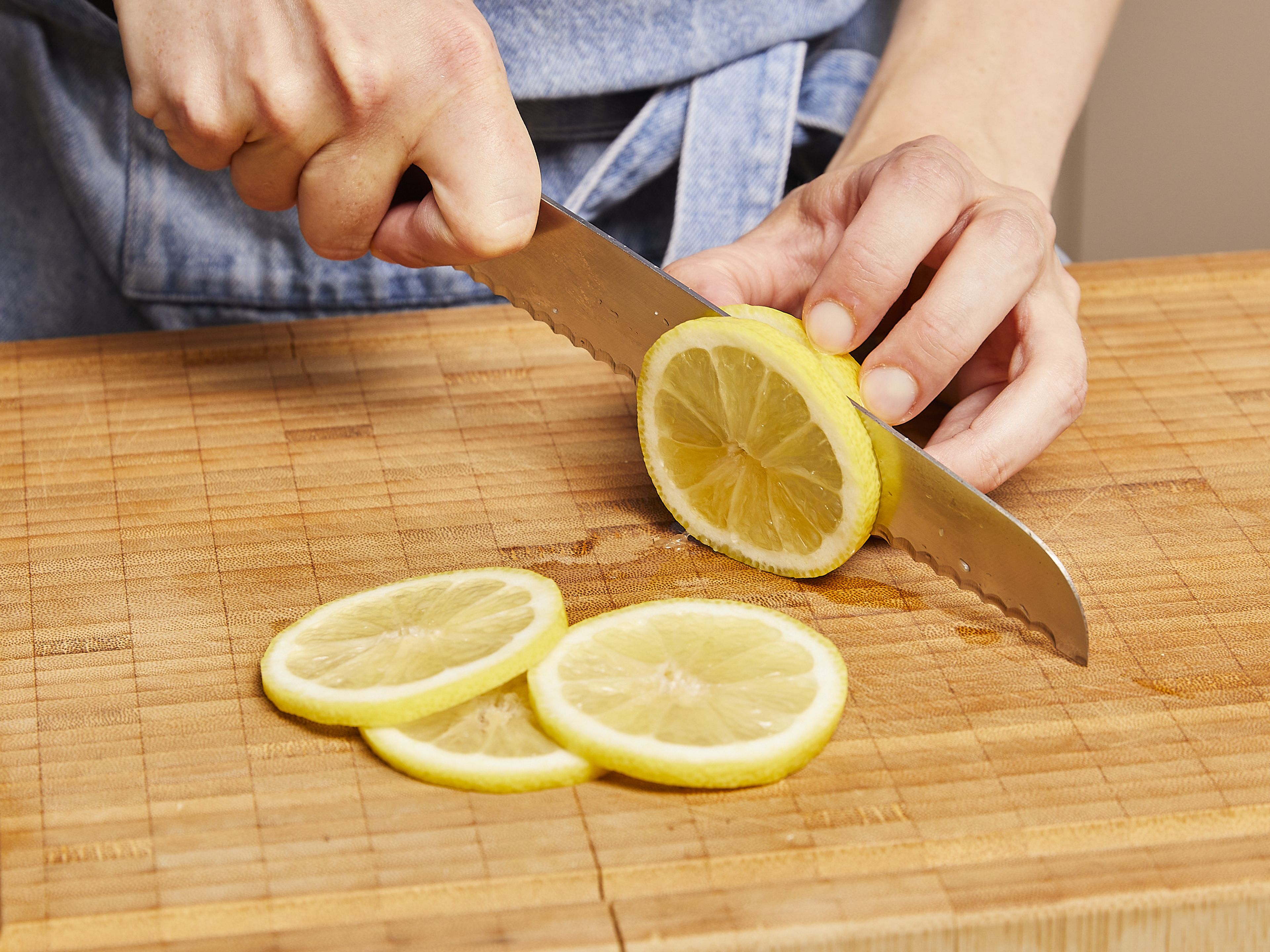 Die Zitrone gründlich waschen und in dünne Scheiben schneiden.