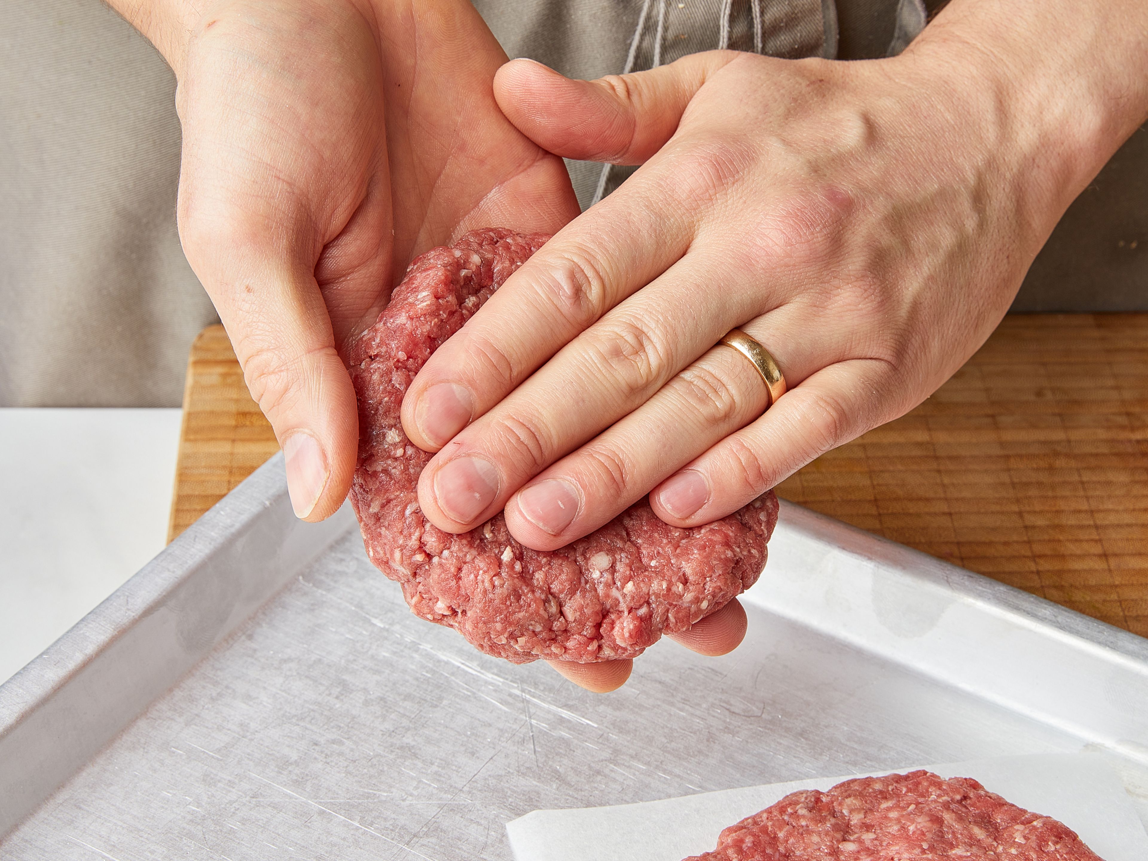 Peel onions and cut into fine rings. For the burger patties, shape the ground beef into one flat burger patty per person, approx. 1 cm/ 0.4 in. thick.