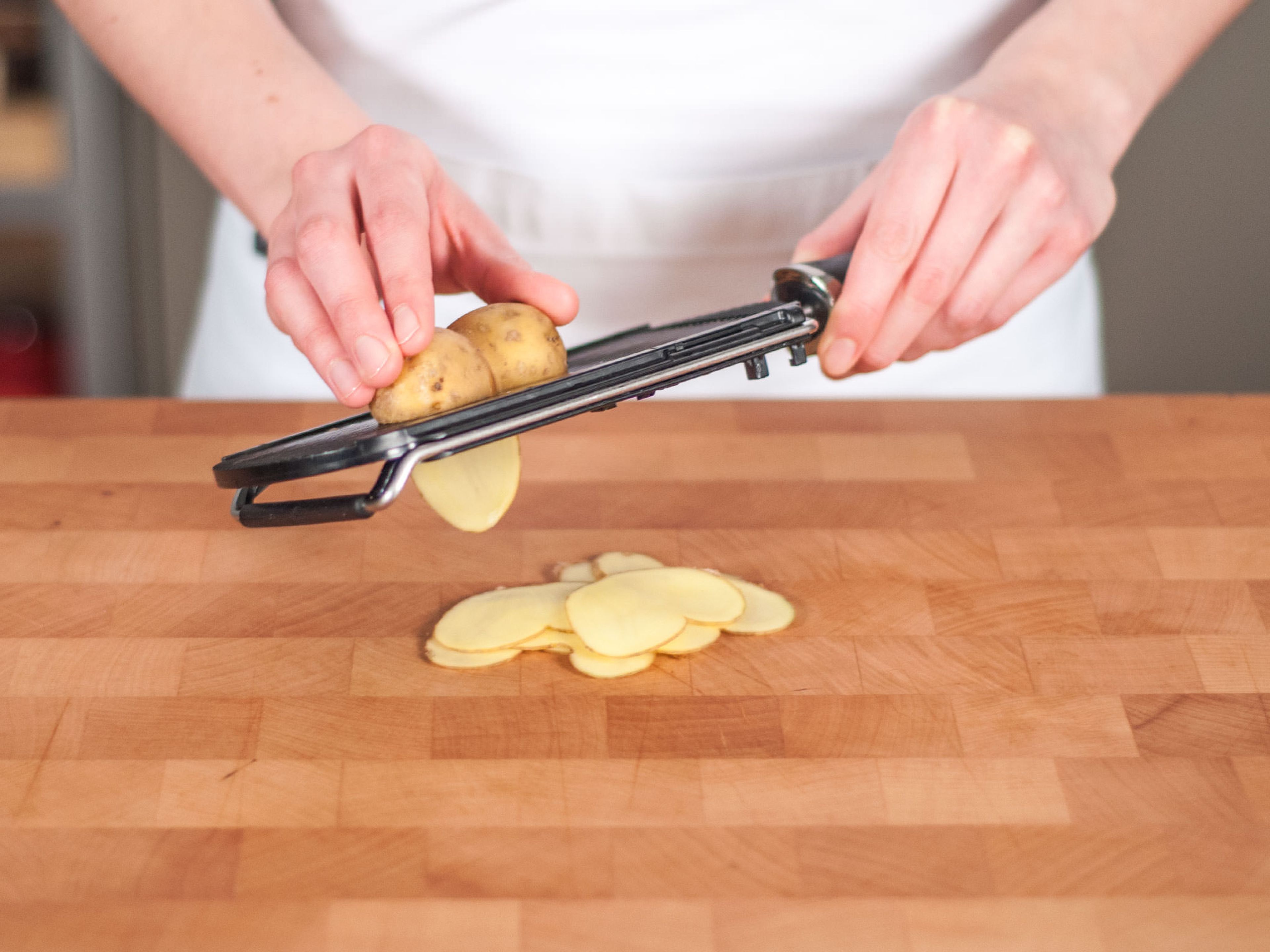 Use slicer or a sharp knife to cut potatoes into thin slices.