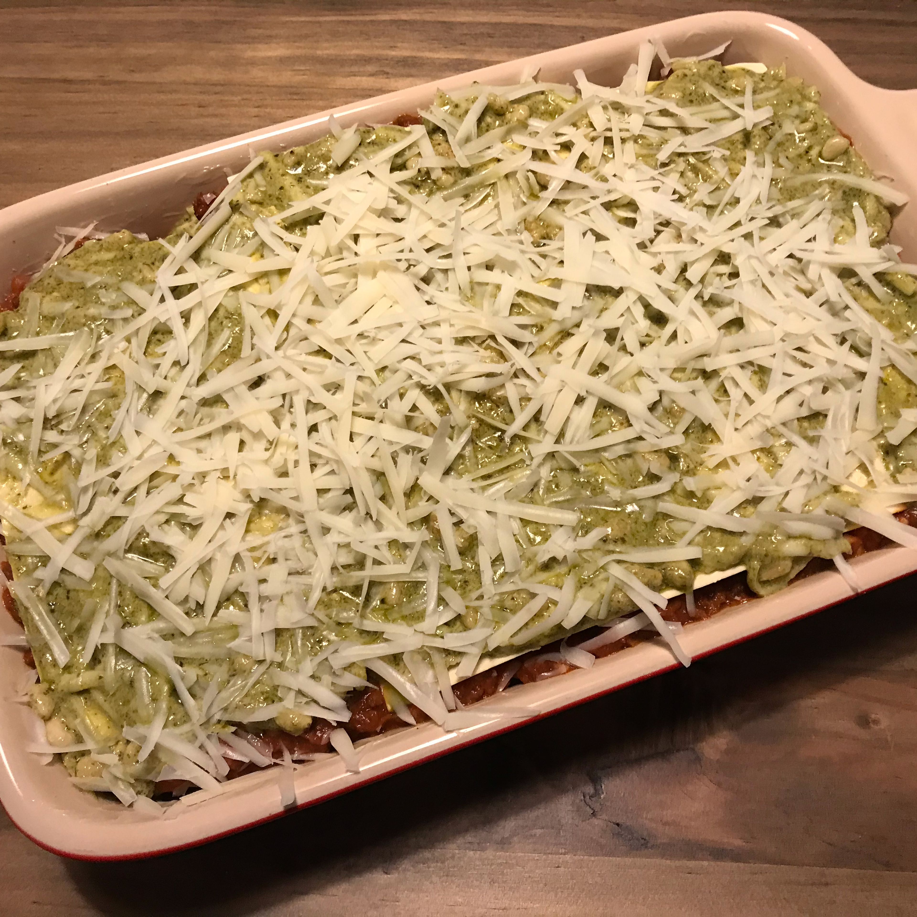 Preheat oven to 180°C/350°F. Slightly grease a baking dish with butter, alternately layer pasta, red filling, pasta, green filling on top of each other. Grate a little nutmeg onto one of the middle layers. Grate the remaining cheese on the top layer. Bake in the oven at 180°C/350°F for approx. 30 min., until the cheese is golden brown.