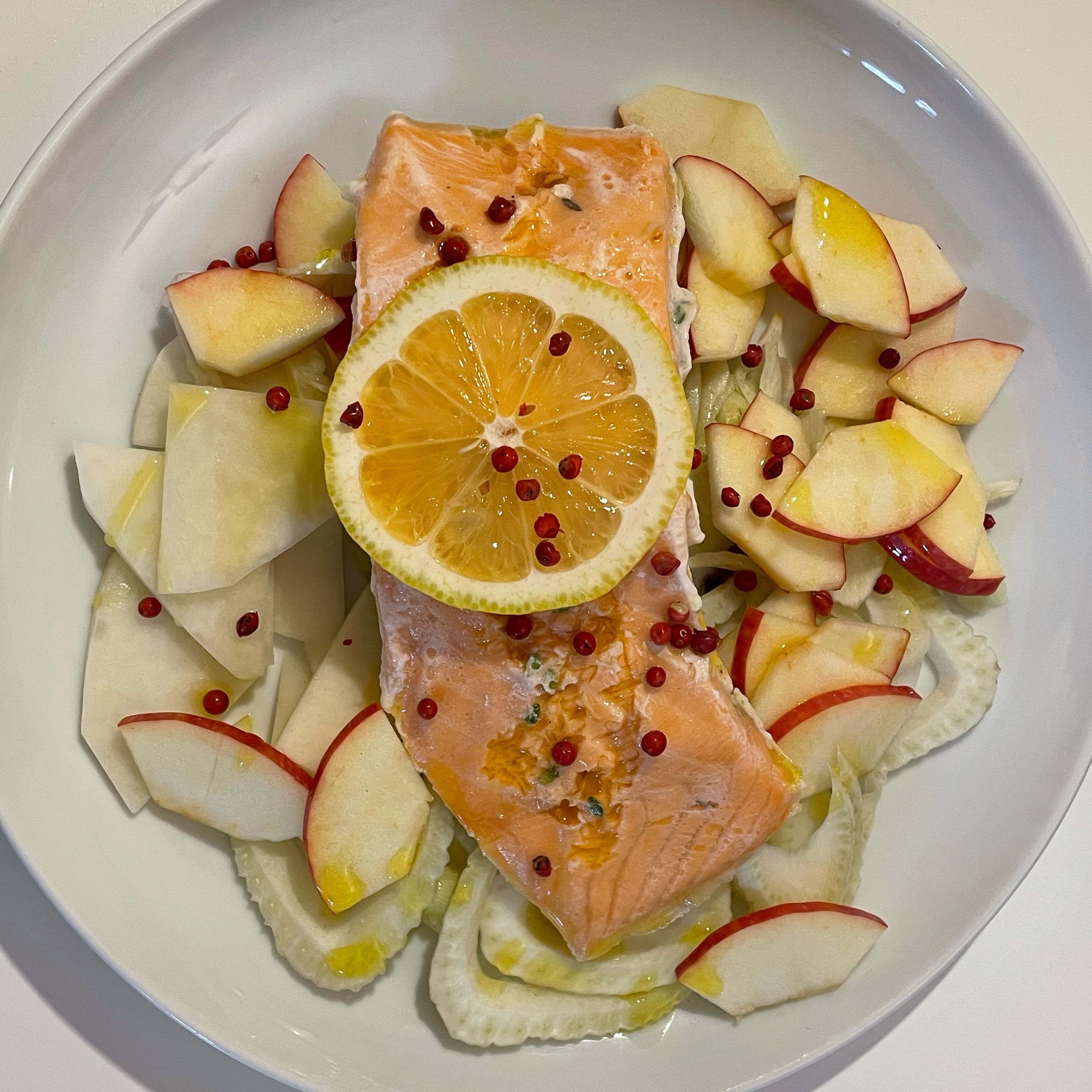 In der Zeit Salat zubereiten. Den Apfel, den Kohlrabi und den Fenchel in 2 mm dicke Scheiben schneiden. Auf zwei Tellern verteilen. Nach 45 Minuten Lachs aus dem Vakuumbeutel nehmen und jeweils auf den Salat legen. Rosa Pfefferbeeren und etwas Fleur de Sel darüber geben. Etwa zwei EL Olivenöl darüber verteilen. (Je nach Geschmack kann der Lachs vorher auch noch kurz auf beiden Seiten scharf angebraten werden.) Mit frischem Ciabatta oder kräftigem Weißbrot servieren. Guten Appetit!