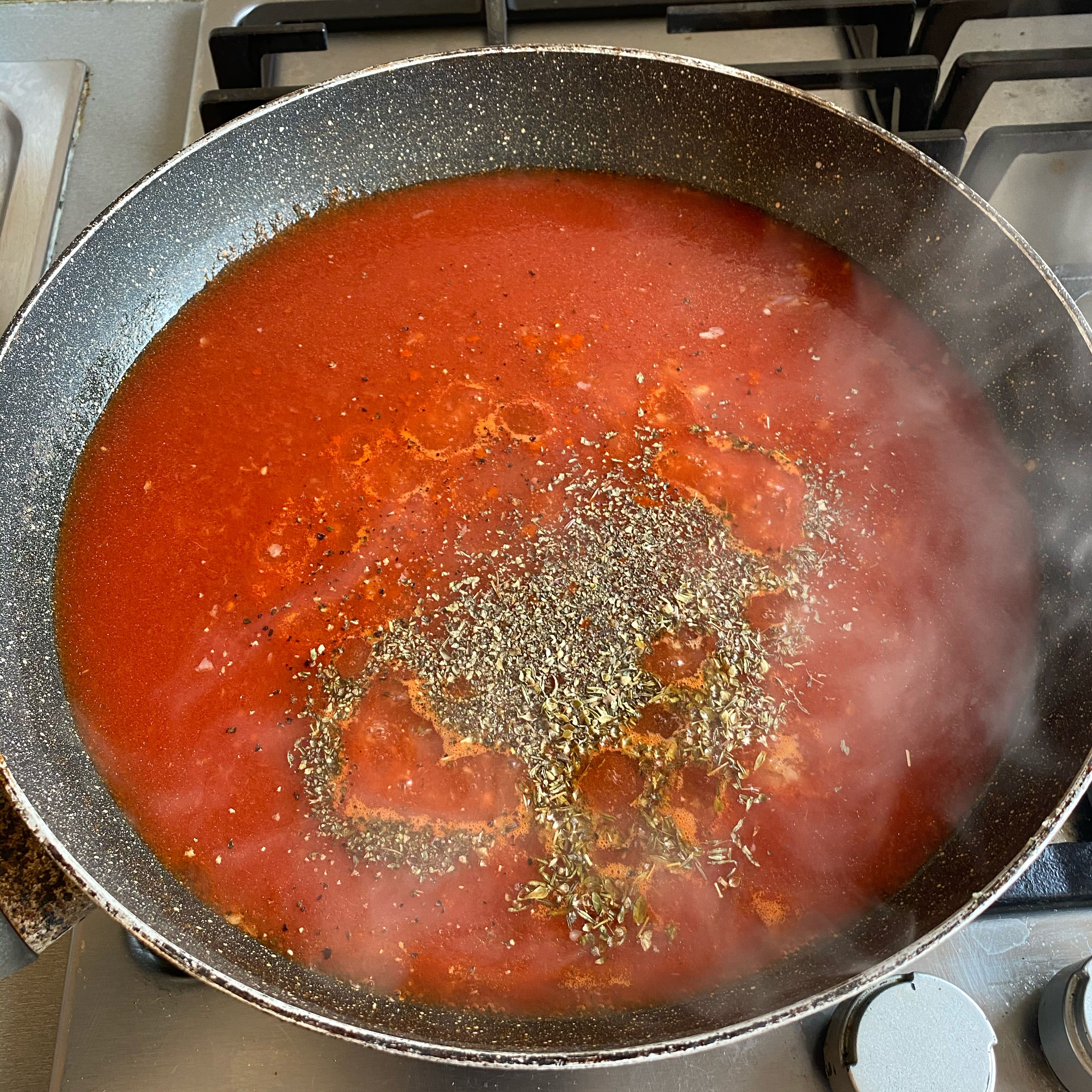 Add the tomato sauce over the sautéed garlic. Turn the heat to low. While the tomato sauce is cooking, add the spices.