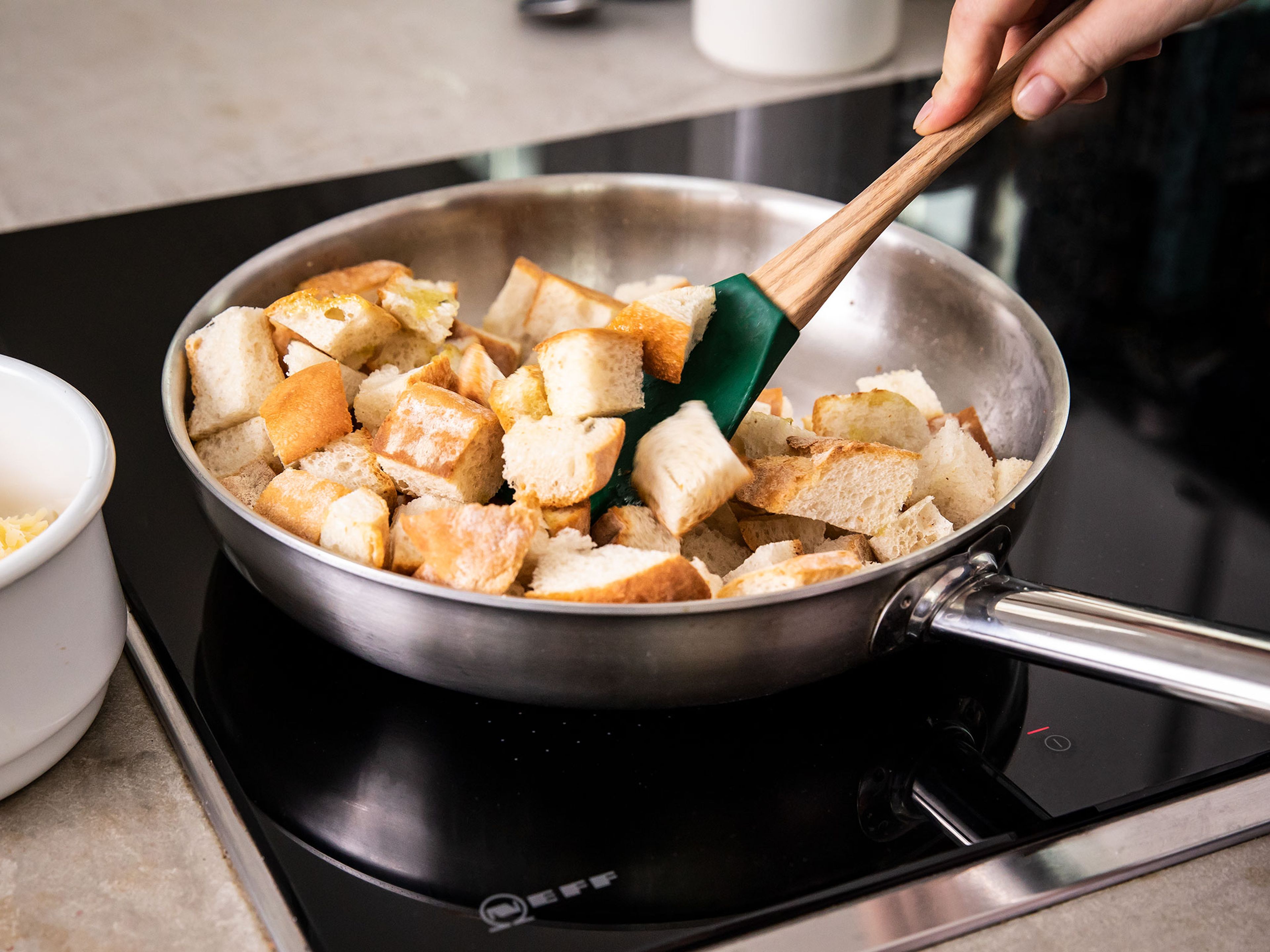 Heat a tablespoon of oil in a frying pan, add the cubed baguette, and fry on medium-high heat on all sides until golden. Season with salt and pepper. Remove the bread from the pan and leave on a plate lined with kitchen towel to soak up excess oil.