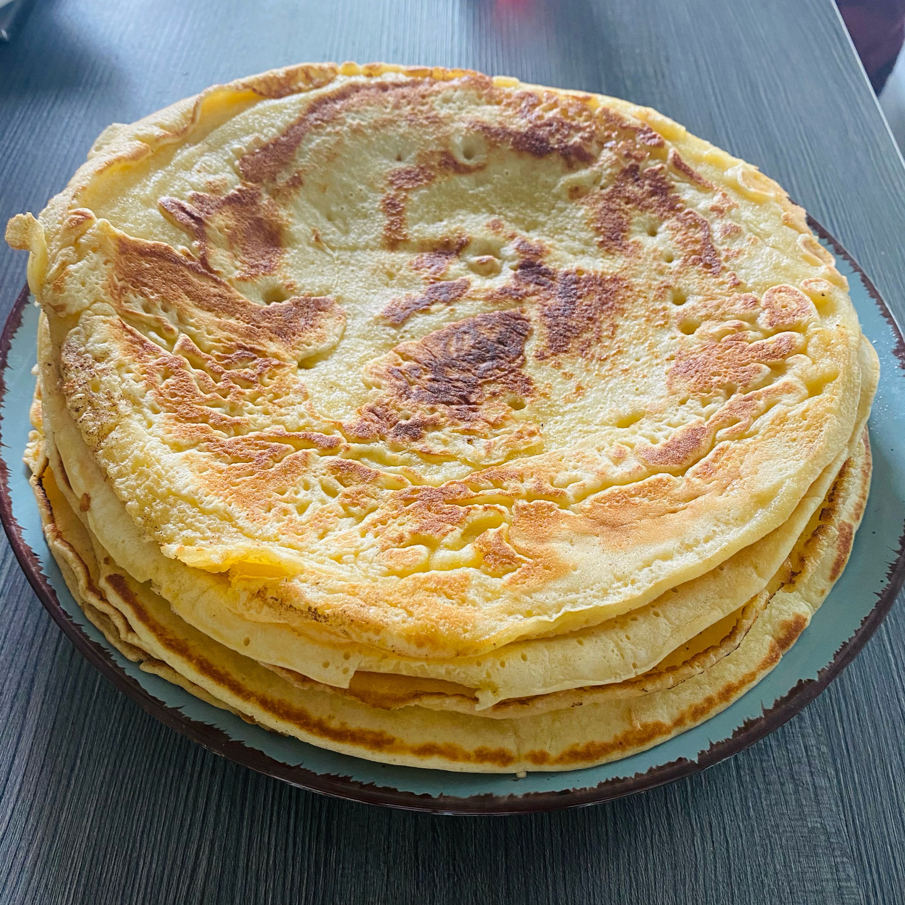 Mehrere Pfannkuchen hintereinander goldgelb ausbacken und nach Wunsch z.B. mit der geschlagenen Sahne, Roter Grütze, Zimt und Zucker genießen.