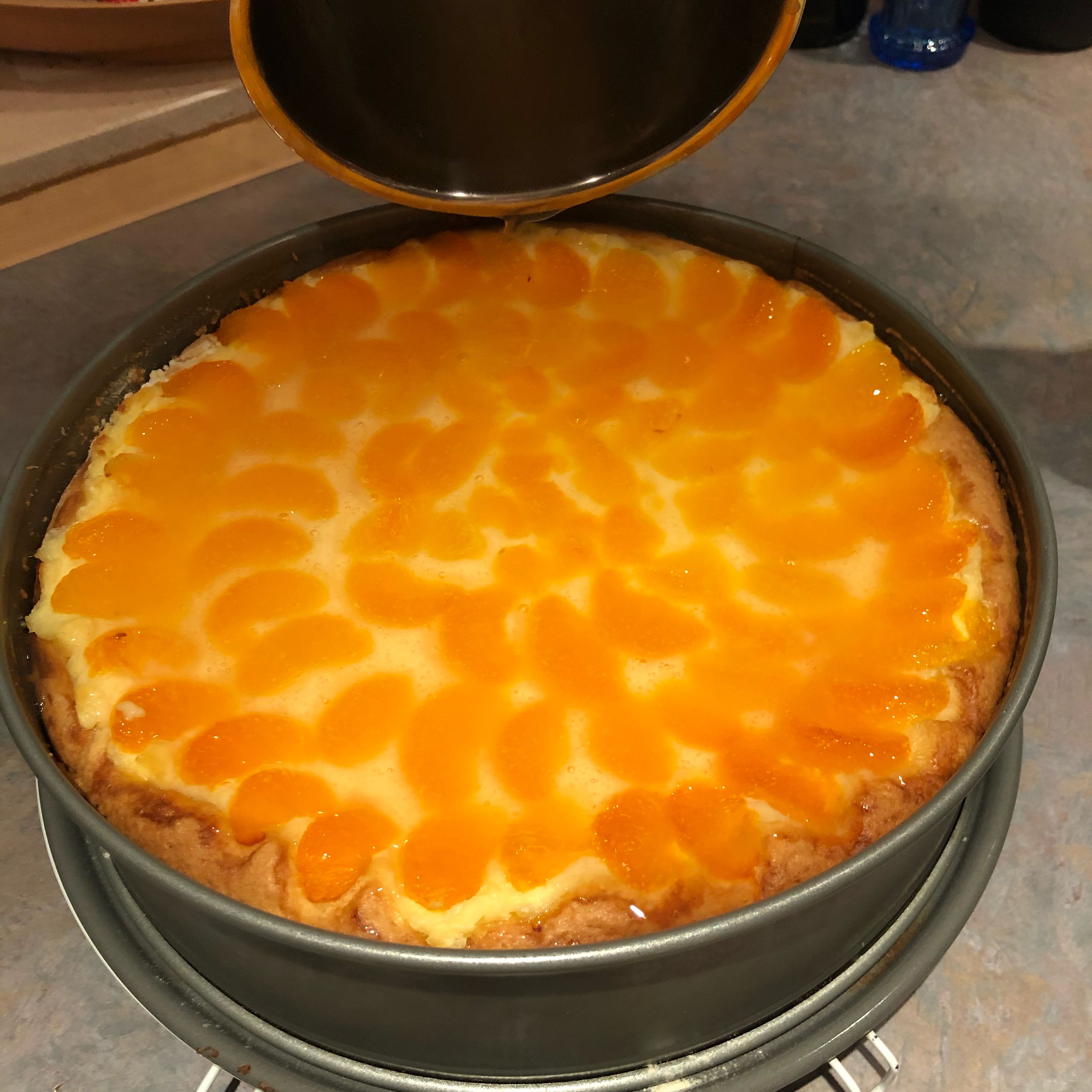 Bereite den Tortenguss zu und bedecke damit die Mandarinen. Lasse den Kuchen erkalten und nehme in aus der Form.