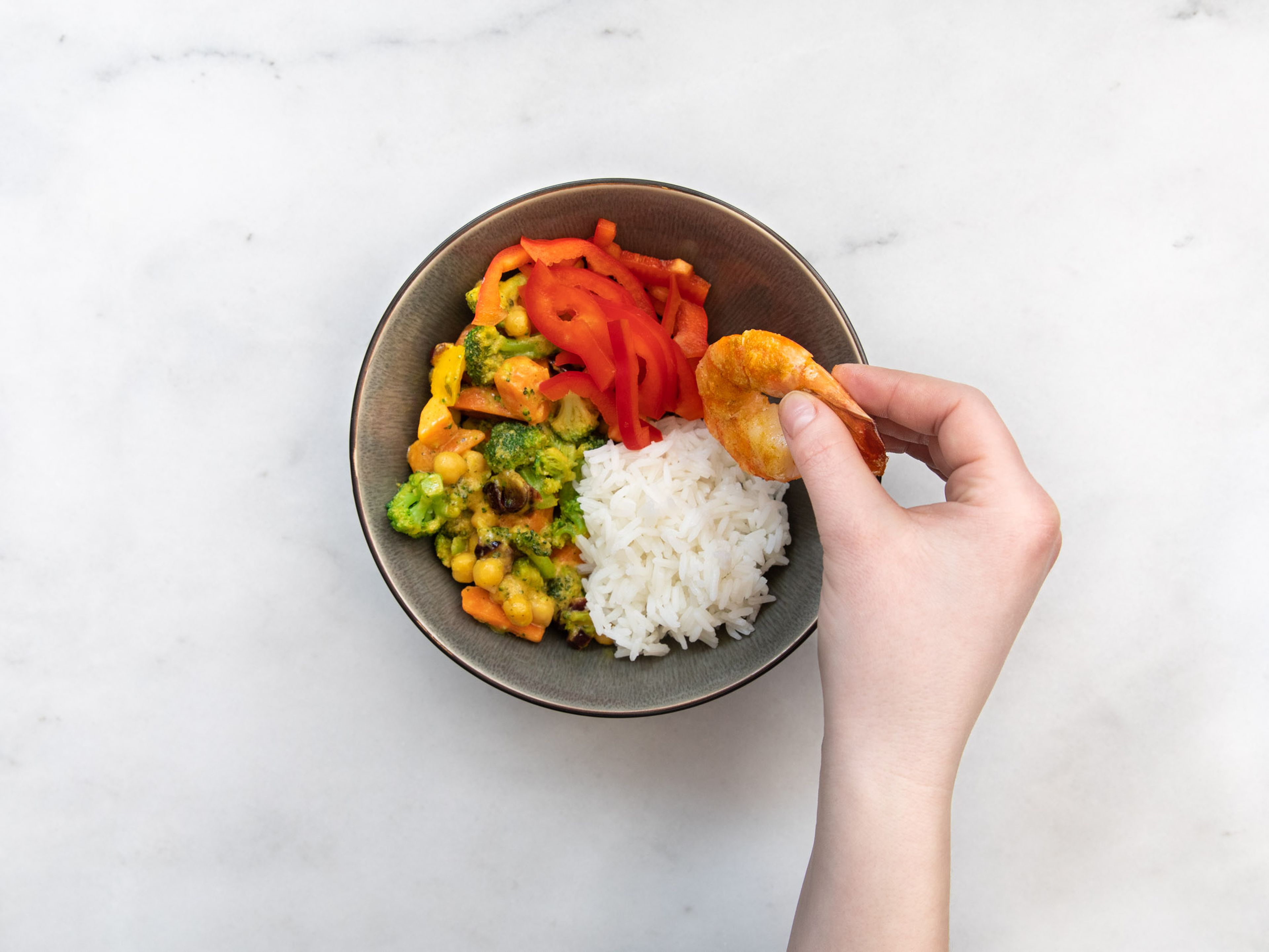 Gemüse mit Reis, roter Paprika, Garnelen und Mayonnaise in einer Schüssel anrichten. Mit Koriander garnieren. Guten Appetit!